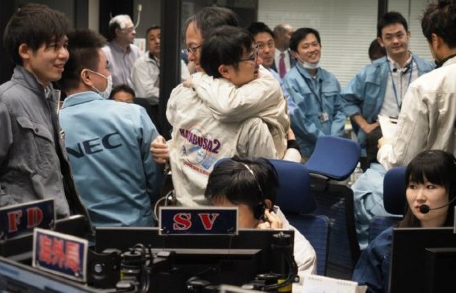 ޖަޕާނުގެ ކޮންޓްރޯޯލް ރޫމްގައި ތިބި މީހުން އުފާ ފާޅު ކުރަނީ. --ފޮޓޯ:އޭއެފްޕީ