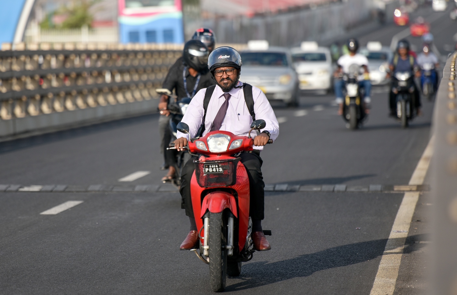 މާލެ: މާޗް 10، 2019- ބްރިޖާއި ހައިވޭން ދަތުރު ކުރާއިރު ހެލްމެޓް އެޅުން މަޖުބޫރު ކުރުމުން މިއަދު ހެނދުނު ހެލްމެޓް އަޅައިގެން ބަޔަކު ސައިކަލްގައި ދަނީ.---ފޮޓޯ: އަހުމަދު ނިޝާތު/މިހާރު