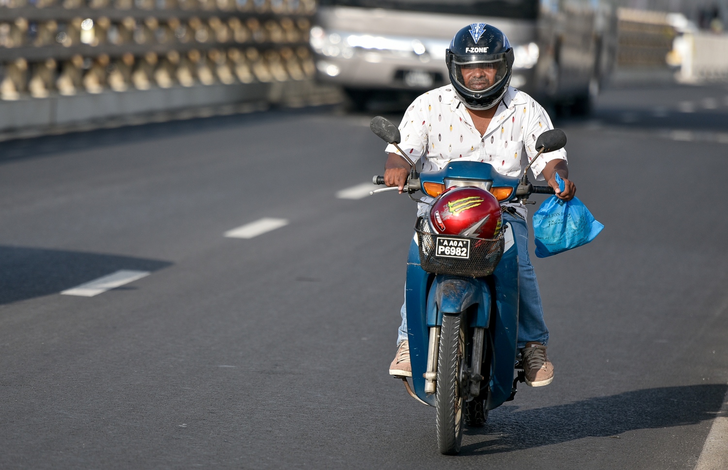 މާލެ: މާޗް 10، 2019- ބްރިޖާއި ހައިވޭން ދަތުރު ކުރާއިރު ހެލްމެޓް އެޅުން މަޖުބޫރު ކުރުމުން މިއަދު ހެނދުނު ހެލްމެޓް އަޅައިގެން މީހަކު ސައިކަލްގައި ދަނީ.---ފޮޓޯ: އަހުމަދު ނިޝާތު/މިހާރު