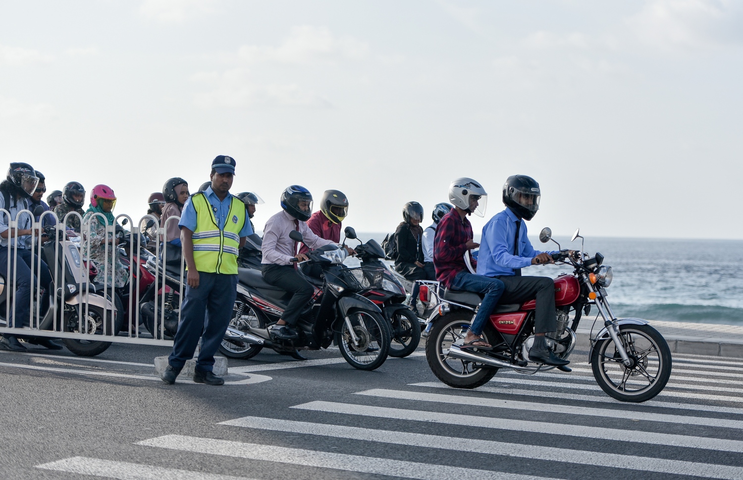 މާލެ: މާޗް 10، 2019- ބްރިޖާއި ހައިވޭން ދަތުރު ކުރާއިރު ހެލްމެޓް އެޅުން މަޖުބޫރު ކުރުމުން މިއަދު ހެނދުނު ހެލްމެޓް އަޅައިގެން ބަޔަކު ސައިކަލްގައި ދާއިރު ޓްރެފިކް ފުލުހަކު މަޑުކޮށްލައިގެން.---ފޮޓޯ: އަހުމަދު ނިޝާތު/މިހާރު