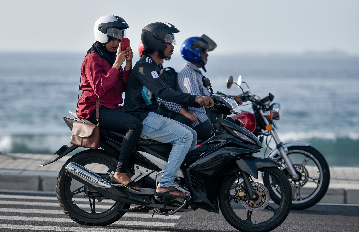 މާލެ: މާޗް 10، 2019- ބްރިޖާއި ހައިވޭން ދަތުރު ކުރާއިރު ހެލްމެޓް އެޅުން މަޖުބޫރު ކުރުމުން މިއަދު ހެނދުނު ހެލްމެޓް އަޅައިގެން ބަޔަކު ސައިކަލްގައި ދަނީ.---ފޮޓޯ: އަހުމަދު ނިޝާތު/މިހާރު