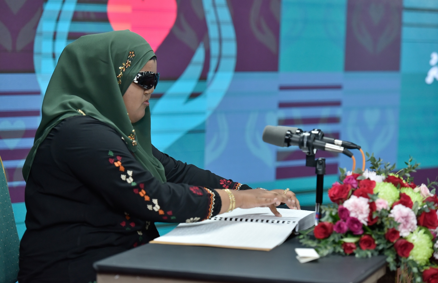 މާލެ: މާޗް 18، 2019: ހާއްސަ އެހީއަށް ބޭނުންވާ މީހުންނަށް އަމާޒުކޮށްގެން ބްރެއިލް ބޭނުންކޮށްގެން ގުރުއާން ކިޔަވައިދޭ ޕްރޮގްރާމެއް އިފްތިތާހުކުރުމަށް އިސްލާމީ މަރުކަޒުގައި ބޭއްވި ރަސްމިއްޔާތެއްގައި ފެނުމުން މަހުރޫމުވެފައިވާ އަންހެން ކުއްޖަކު ބްރެއިލް ބޭނުންކޮށްގެން ކިޔަވަނީ.-- ފޮޓޯ: އހަުމަދު ނިޝާތު /މިހާރު