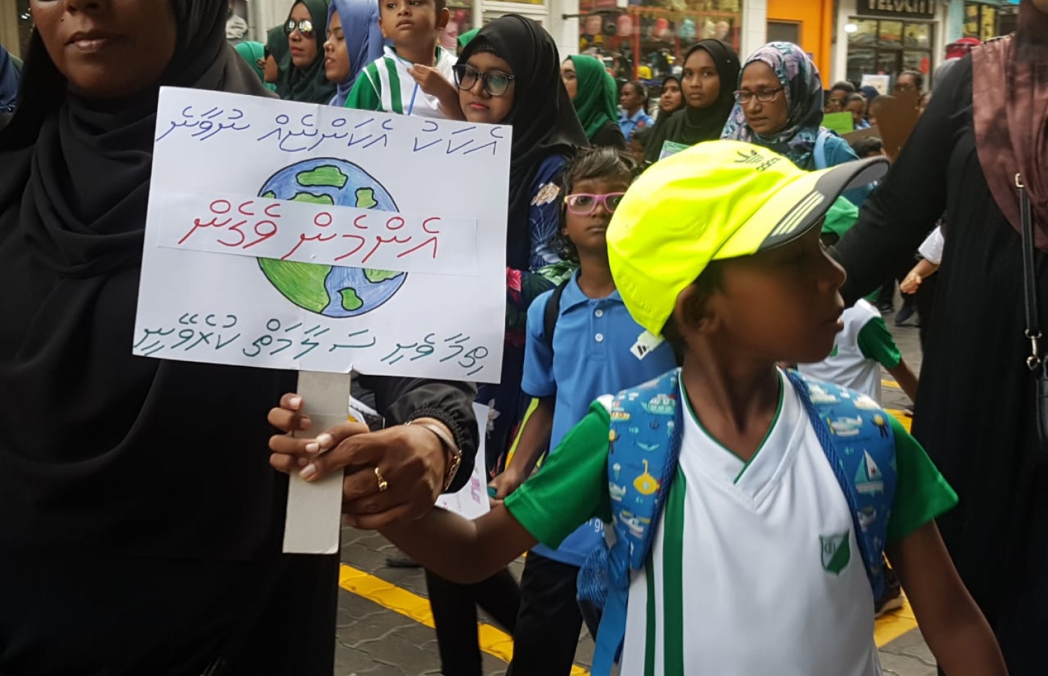 ކްލައިމެޓް މާޗުގައި ބައިވެރިވި ދަރިވަރަކު ތިމާވެއްޓާ ބެހޭ ލިއުމެއް ހިފައިގެން -- ފޮޓޯ: އެމެރިކަން ސެންޓަރު