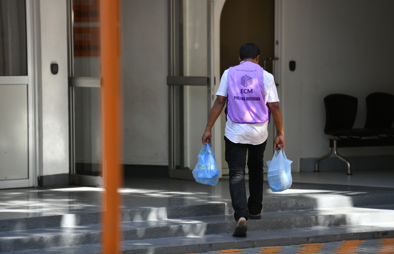 މާލެ: އޭޕްރިލް 6، 2019: ރައްޔިތުންގެ މަޖިލިސް އިންތިހާބުގައި ވޯޓުލަމުންދާ މަރުކަޒަކަށް އޮފިޝަލަކު ފެންފުޅިތަކެއް ހިފައިގެން ވަންނަނީ.-- ފޮޓޯ: ހުސެން ވަހީދު /މިހާރު