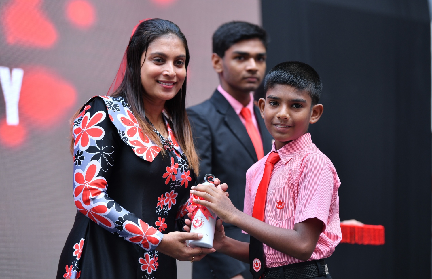 މާލެ: އޭޕްރިލް 25، 2019: އިސްކަންދަރު ސްކޫލަށް 58 އަހަރު ފުރުން ފާހަގަ ކުރުމުގެ ގޮތުން އެ ސްކޫލުގައި ބޭއްވި ރަސްމިއްޔާތެއްގައި އެޑިއުކޭޝަން މިނިސްޓަރު އައިޝަތު އަލީ ދަރިވަރަކަށް ފެން ފުޅިއެއް ހަދިޔާ ކުރައްވަނީ.-- ފޮޓޯ: ހުސެއިން ވަހީދު /މިހާރު