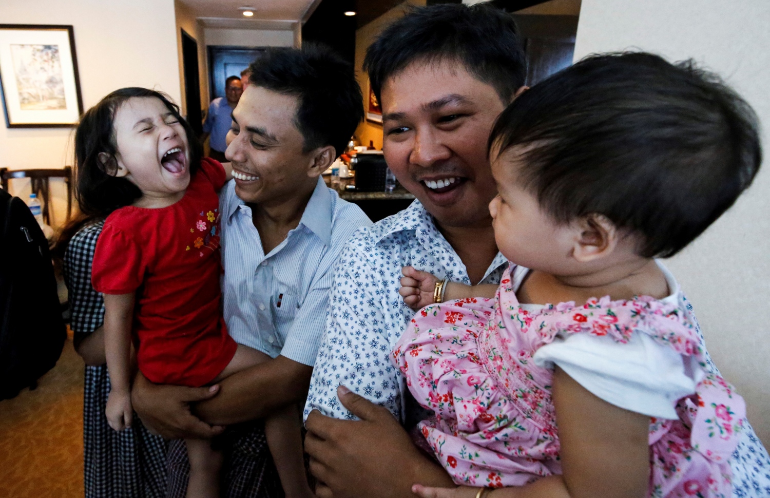 ޖަލުން ދޫކޮށްލި ރޮއިޓާސްގެ ދެ ނޫސްވެރިން ކަމަށްވާ ވަ ލޯން އާއި ކިޔޯ ސޮއެ އޫ އެ މީހުންގެ ދަރިންނާ އެކު އުފާފާޅު ކުރަނީ. --ފޮޓޯ:އޭއެފްޕީ