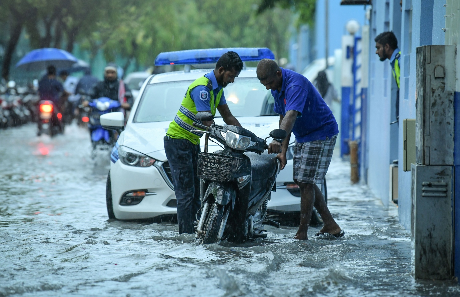 މާލެ- މެއި 23، 2019- ހުޅަނގު މޫސުމުގެ ވިއްސާރައާ އެކު މާލެ އަށް މިއަދު ހެނދުނުއްސުރެ ފެށިގެން ވެހެމުންދާ ބޯ ވާރޭގައި ފެން ބޮޑުވެފައިވާ މަގެއްގައި ސައިކަލެއް ޕާކް ކުރަން ފުލުހަކު މީހަކަށް އެހީތެރިވަނީ.---ފޮޓޯ: ނިޝާން އަލީ/މިހާރު