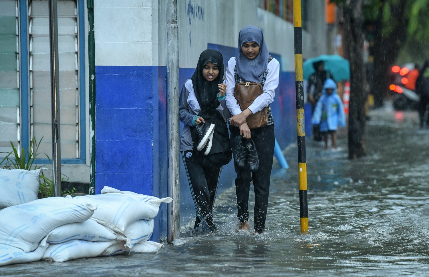 މާލެ- މެއި 23، 2019- ހުޅަނގު މޫސުމުގެ ވިއްސާރައާ އެކު މާލެ އަށް މިއަދު ހެނދުނުއްސުރެ ފެށިގެން ވެހެމުންދާ ބޯ ވާރޭގައި ފެން ބޮޑުވެފައިވާ މަގެއްގައި ސްކޫލް ކުދިންތަކެއް ހިނގާފައި ދަނީ.---ފޮޓޯ: ނިޝާން އަލީ/މިހާރު