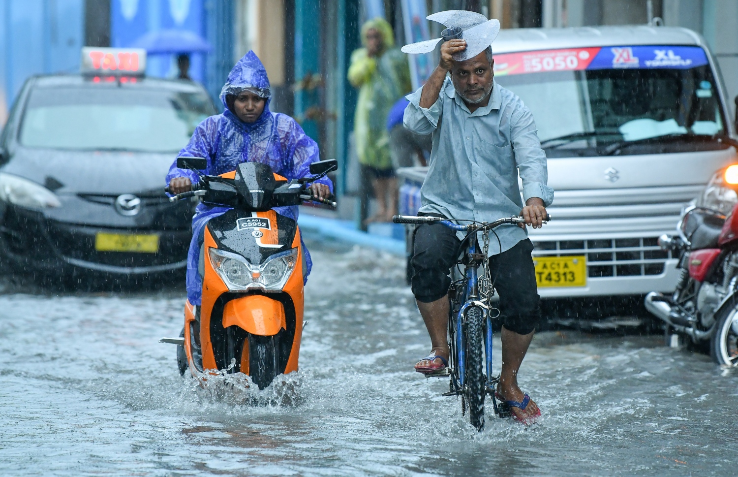 މާލެ- މެއި 23، 2019- ހުޅަނގު މޫސުމުގެ ވިއްސާރައާ އެކު މާލެ އަށް މިއަދު ހެނދުނުއްސުރެ ފެށިގެން ވެހެމުންދާ ބޯ ވާރޭގެ ތެރޭގައި ފެން ބޮޑުވެފައިވާ މަގެއްގައި ބަޔަކު ދުއްވާފައި ދަނީ.---ފޮޓޯ: ނިޝާން އަލީ/މިހާރު