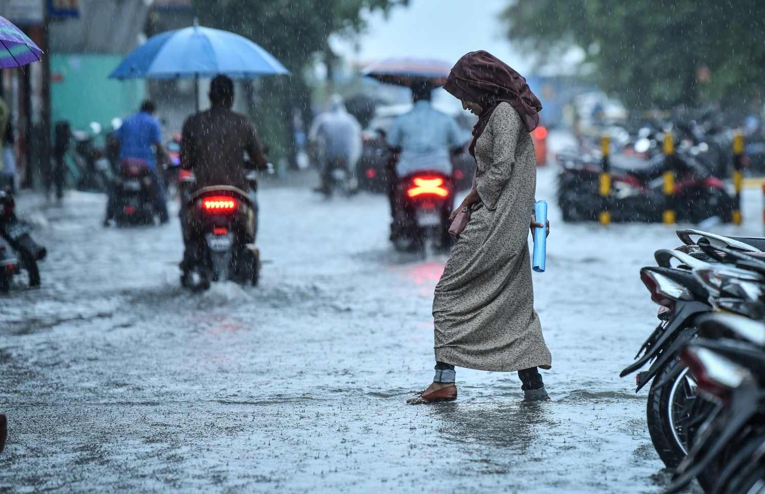 މާލެ- މެއި 23، 2019- ހުޅަނގު މޫސުމުގެ ވިއްސާރައާ އެކު މާލެ އަށް މިއަދު ހެނދުނުއްސުރެ ފެށިގެން ވެހެމުންދާ ބޯ ވާރޭގެ ތެރޭގައި މީހަކު ކުޑަ އަޅައިގެން ހިނގާފައި ދަނީ.---ފޮޓޯ: ނިޝާން އަލީ/މިހާރު