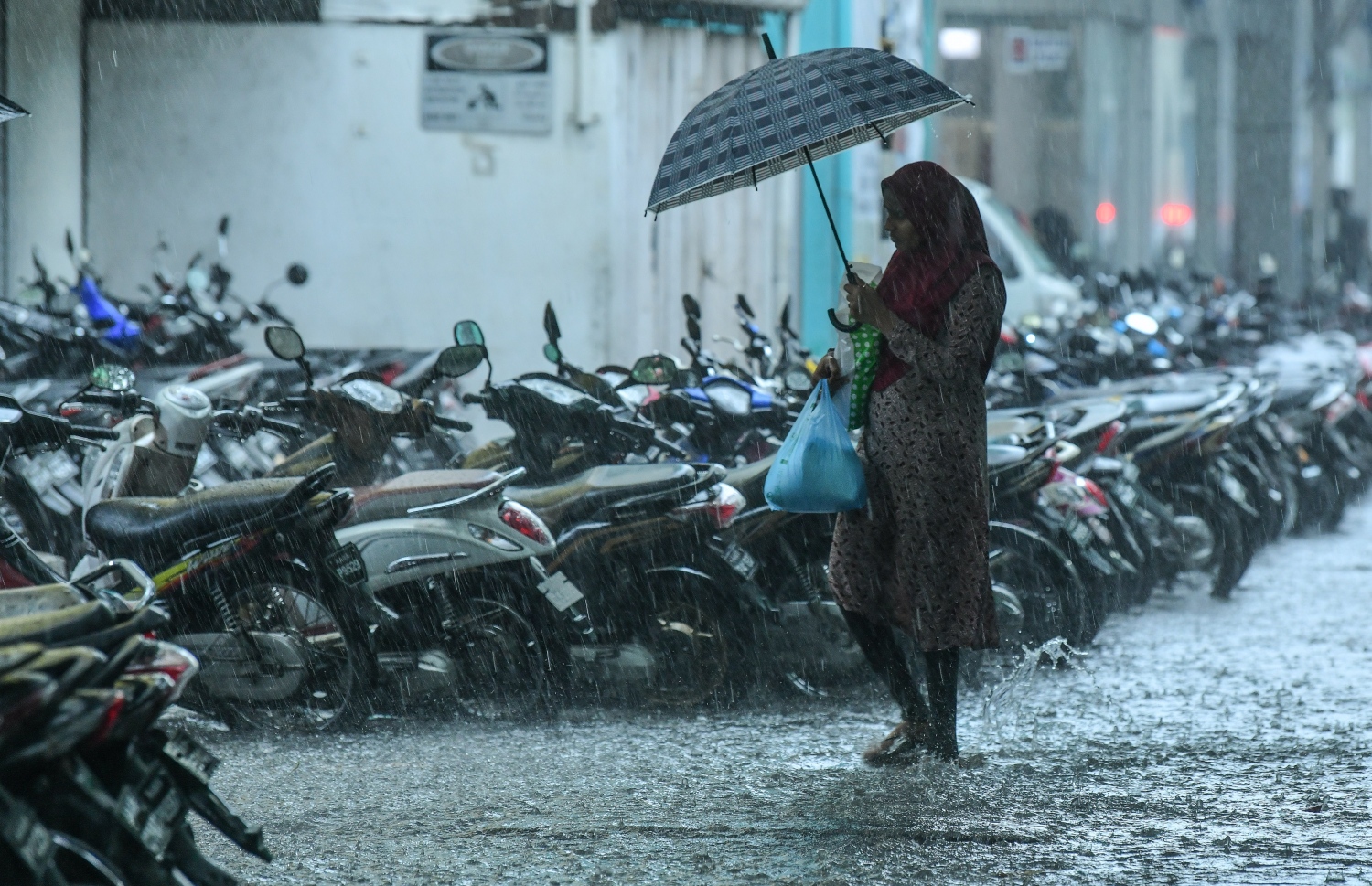 މާލެ- މެއި 23، 2019- ހުޅަނގު މޫސުމުގެ ވިއްސާރައާ އެކު މާލެ އަށް މިއަދު ހެނދުނުއްސުރެ ފެށިގެން ވެހެމުންދާ ބޯ ވާރޭގެ ތެރޭގައި މީހަކު ކުޑަ އަޅައިގެން ހިނގާފައި ދަނީ: މިއަދު ވެހެން ފެށި ވާރޭ އާ އެކު މެޓް އޮފީހުން ވަނީ ރާއްޖޭގެ ބޮޑު ސަރަހައްދަކަށް ވައިޓް އެލާޓް ވެސް ނެރެފައި.-- ފޮޓޯ: ނިޝާން އަލީ/މިހާރު