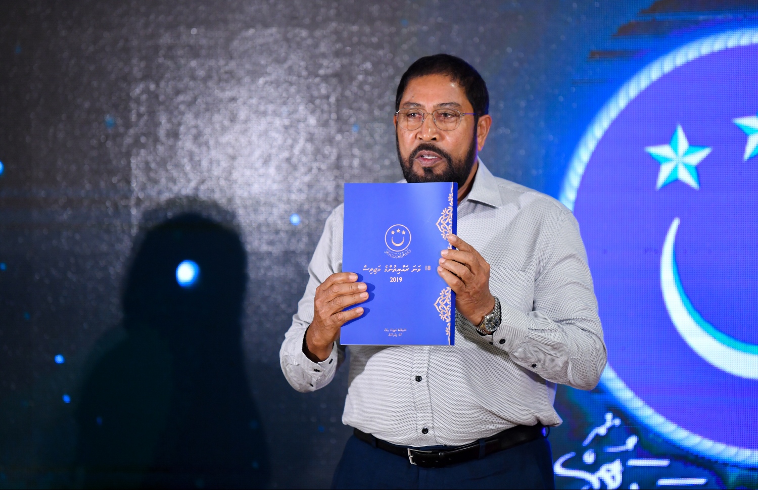 މާލެ: މޭ 26، 2019- މިހާރު ހިނގަމުން އަންނަ 18 ވަނަ ރައްޔިތުންގެ މަޖިލިހުގެ މަސައްކަތްތަކާ ގުޅޭ ފޮތް، މަޖިލިހުގެ ރައީސް ގާސިމް މިރޭ ނެރެދެއްވަނީ.---ފޮޓޯ: ހުސައިން ވަހީދު/މިހާރު