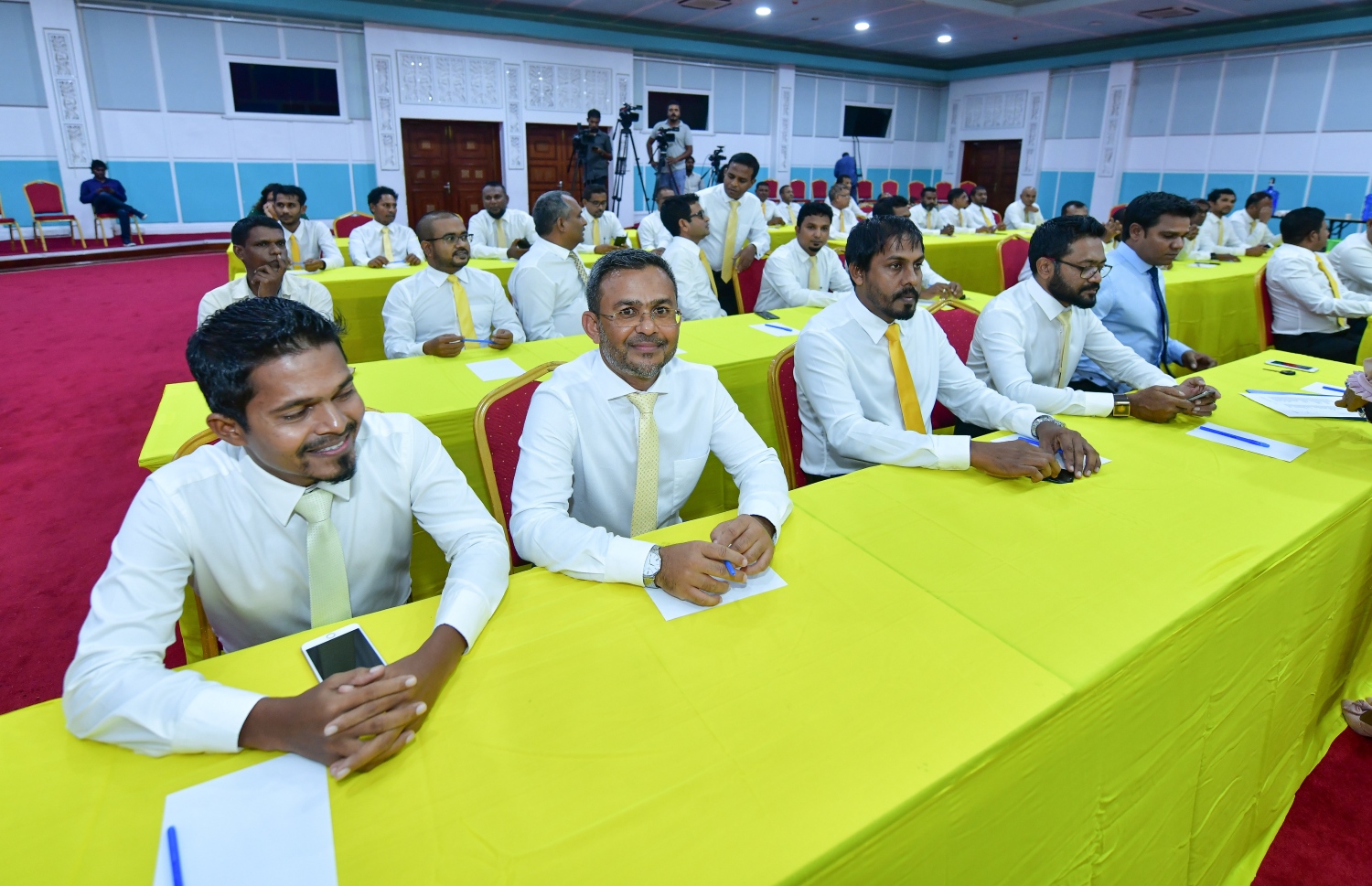 މާލެ- 27 މެއި 2019: ނަވާރަ ވަނަ ރައްޔިތުންގެ މަޖިލީހުގެ ރައީސް ކަމާއި ނައިބު ރައީސް ކަމަށް އެމްޑީޕީން ހުށަހަޅާ ކެންޑިޑޭޓަކު ހޮވުމަށް ދަރުބާރުގޭގައި ބޭއްވި ރަސްމިއްޔާތުގައި ބައިވެރިވި އެޕާޓީގެ ބައެއް މަޖިލިސް މެމްބަރުން --.ފޮޓޯ:ނިޝާން އަލީ/މިހާރު