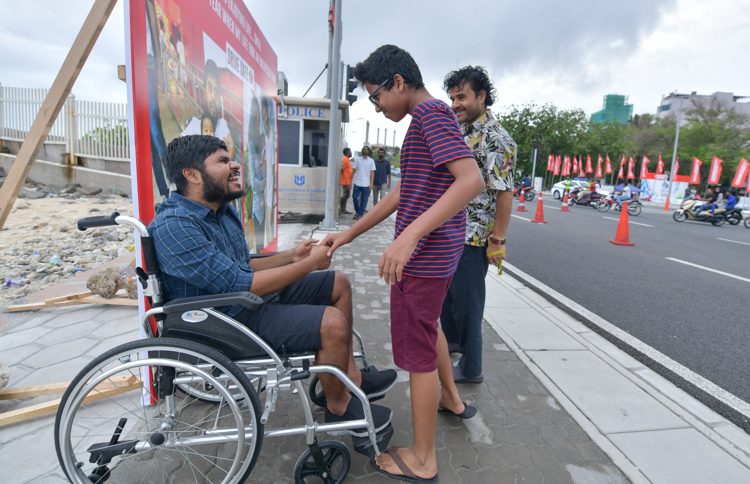 މާލެ: މެއި 29، 2019: އޮއްތޮގެ އެކްސިޑެންޓަށް އެއް އަހަރު ފުރުމާ ދިމާކޮށް، މީހުން ހޭލުންތެރި ކުރުމަށް އޭނާގެ އާއިލާ އާއި "މިހާރު" ގުޅިގެން މާލޭގައި ޕޯސްޓަރެއް ބެހެއްޓުށް ބޭއްވި އިވެންޓުގައި އޮއްތު ރައްޓެހިންތަކަކާ ސަލާމް ކުރަނީ.---ފޮޓޯ: ނިޝާން އަލީ/މިހާރު