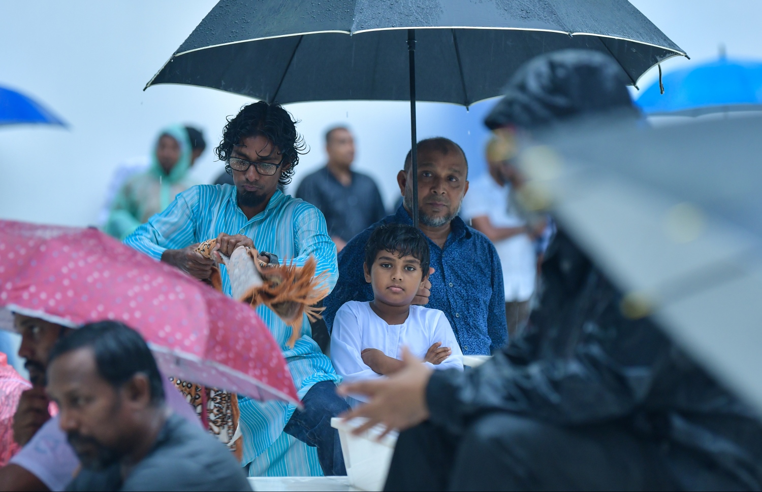 މާލެ: ޖޫން 4، 2019- ފިތުރު އީދު ނަމާދަށް އިސްލާމީ މަރުކަޒަށް ދިޔަ ބަޔަކު، ވެހެމުން ދިޔަ ވާރޭގެ ތެރޭގައި މިސްކިތުގެ ބޭރުގައި ކުޑަ ނަގައިގެން ތިބެ ހުތުބާ އަޑުއަހަނީ.---ފޮޓޯ: ހުސައިން ވަހީދު/މިހާރު