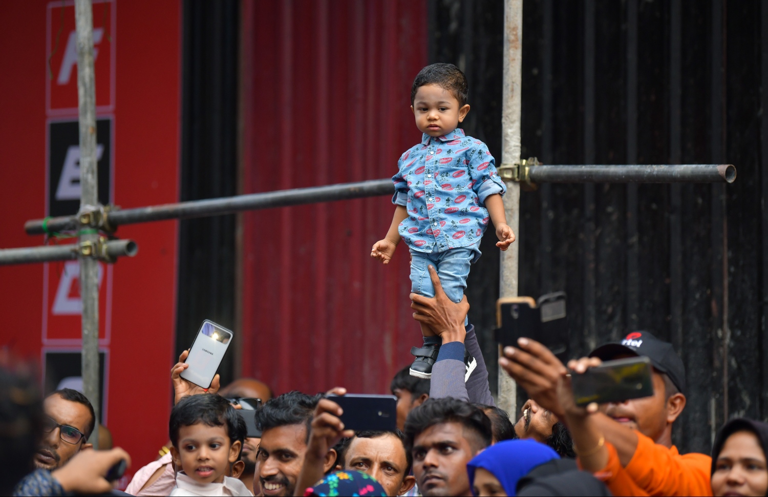 މާލެ: ޖޫން 4، 2019- މަޖީދީ މަގުގައި ކުރިއަށްދިޔަ ސަގާފީ ކުޅިވަރުތައް ބަލަން ގޮސްތިބި މީހުންގެ ތެރެއިން މީހަކު ކުޑަކުއްޖެއް އުފުއްލާލައިގެން.---ފޮޓޯ: ހުސައިން ވަހީދު/މިހާރު