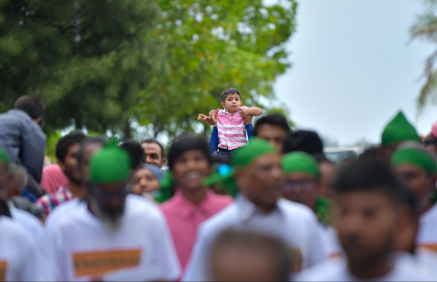 މާލެ: ޖޫން 4، 2019- މަޖީދީ މަގުގައި ކުރިއަށްދިޔަ ސަގާފީ ކުޅިވަރުތައް ބަލަން ދިޔަ ކުޑަކުއްޖެއް މީހެއްގެ ކޮނޑަށް އަރައިގެން މާލިތައް ބަލަނީ.---ފޮޓޯ: ހުސައިން ވަހީދު/މިހާރު