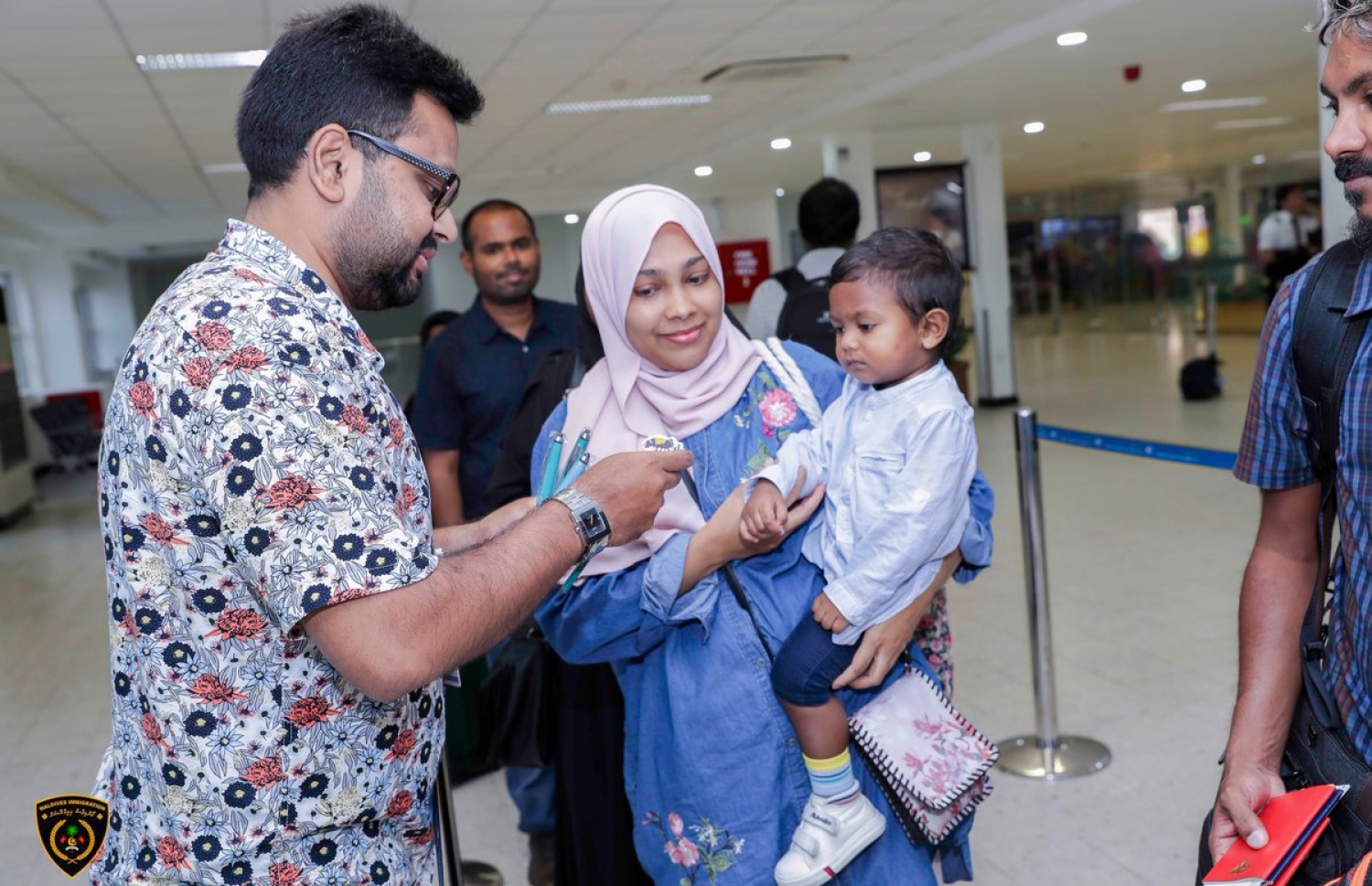 އިމިގްރޭޝަން ކޮންޓްރޯލާ (ވ) ކުއްޖަކަށް ހަދިޔާއެއް ދެއްވަނީ. --- ފޮޓޯ: އިމިގްރޭޝަން