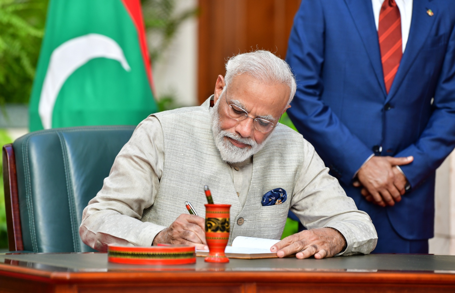 މާލެ: ޖޫން 8، 2019- އިންޑިއާގެ ބޮޑުވަޒީރު ނަރެންދުރަ މޯދީ ރަސްމީ ދަތުރުފުޅެއްގައި ރާއްޖެ ވަޑައިގަތުމަށްފަހު ރައީސް އޮފީހަށް ވަޑައިގެން މެހެމާނުންގެ ފޮތުގައި ސޮއި ކުރައްވަނީ.---ފޮޓޯ: ނިޝާން އަލީ/މިހާރު