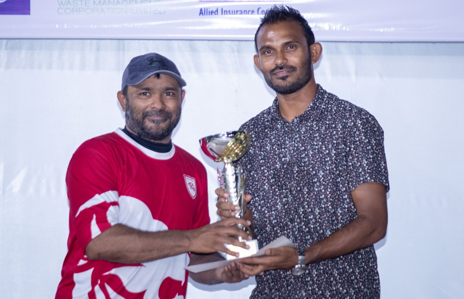 މިސްޓަ ބައިބަލާ ކުޑަ މައްލާ (ވ) އާ ޔޫތު މިނިސްޓްރީގެ ސްޓޭޓް މިނިސްޓަރު އަސްހަދު އަލީ ޓްރޮފީ ހަވާލުކުރަނީ. -- ފޮޓޯ: އިމޭޖަސް،އެމްވީ