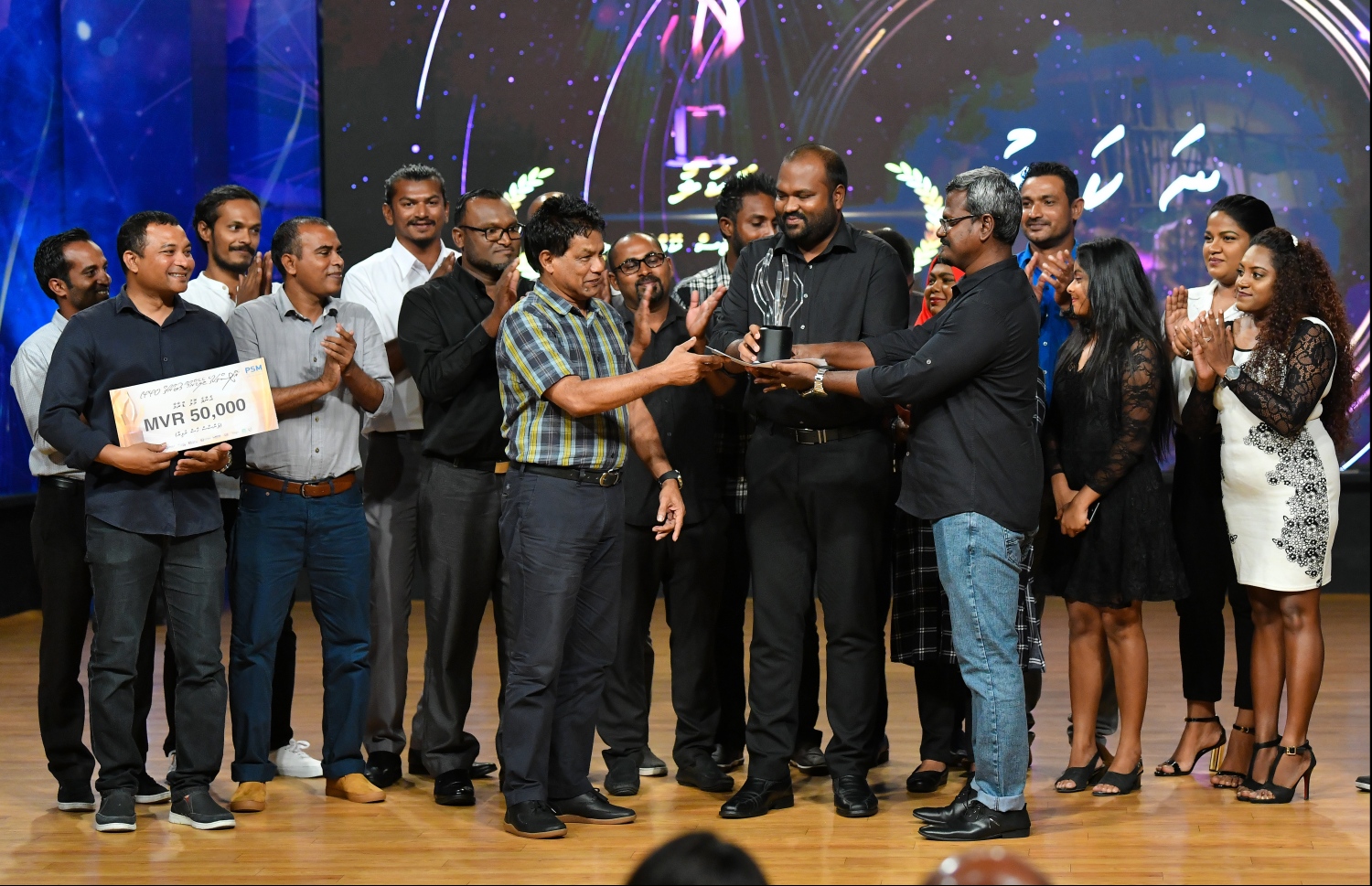 މާލެ: ޖޫން 21، 2019- ޕީއެސްއެމް އޮފީސްތަކުގެ ޓެލެޑްރާމާ މުބާރާތުގެ އެވޯޑު ހަފުލާގައި، އެންމެ މޮޅު ޑްރާމާގެ އެވޯޑު ލިބުނު އެމްއޭސީއެލްގެ ޑްރާމާ "ނަކަލު"ގެ ޓީމަށް ޓޫރިޒަމް މިނިސްޓަރު އަލީ ވަހީދު އެވޯޑު ދެއްވަނީ---ފޮޓޯ: ހުސައިން ވަހީދު/މިހާރު