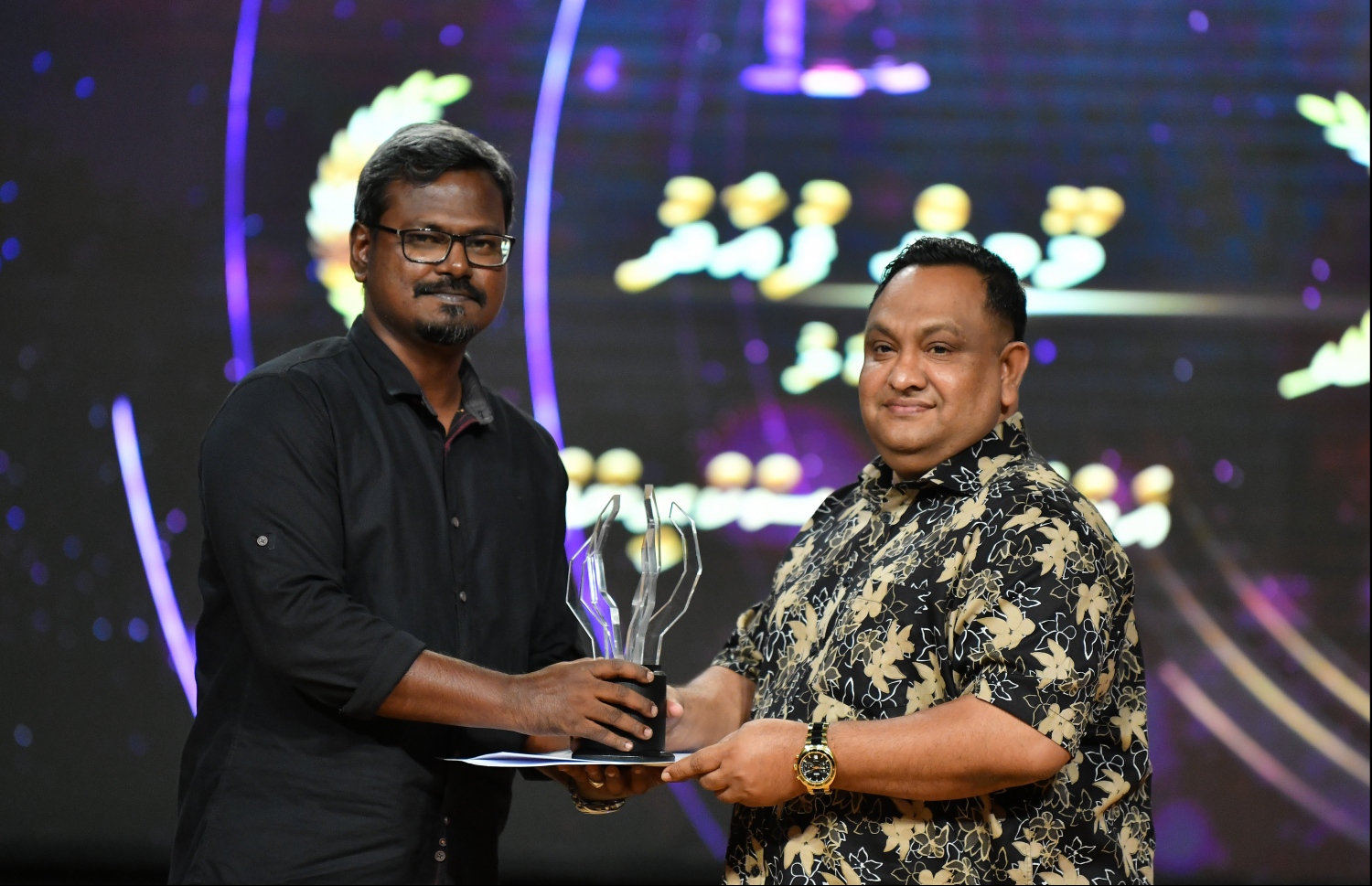 މާލެ: ޖޫން 21، 2019- ޕީއެސްއެމް އޮފީސްތަކުގެ ޓެލެޑްރާމާ މުބާރާތުގެ އެވޯޑު ދިނުމުގެ ހަފްލާގައި އެމްއޭސީއެލްގެ ޑްރާމާ "ނަކަލު"ގެ ޑައިރެކްޓަރު ކޮޕީ އިސްމާއިލް ރަޝީދަށް އެވޯޑު ދެނީ.---ފޮޓޯ: ހުސައިން ވަހީދު/މިހާރު