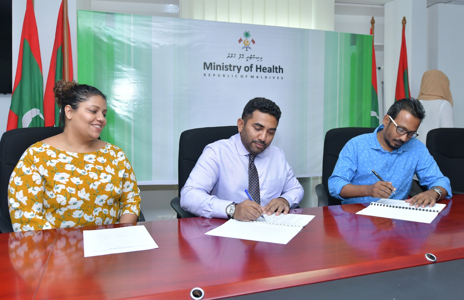 ހިންނަވަރު ސިއްހީ މަރުކަޒު، ހޮސްޕިޓަލަކަށް ބަދަލުކުރުމުގެ ޑިޒައިން އެއްބަސްވުމުގައި މިނިސްޓަރު އަމީން ސޮއިކުރައްވާއިރު، އެ ދާއިރާގެ މެމްބަރު ޖީހާން އަރިހުގައި.---ފޮޓޯ: ނިޝާން އަލީ/މިހާރު