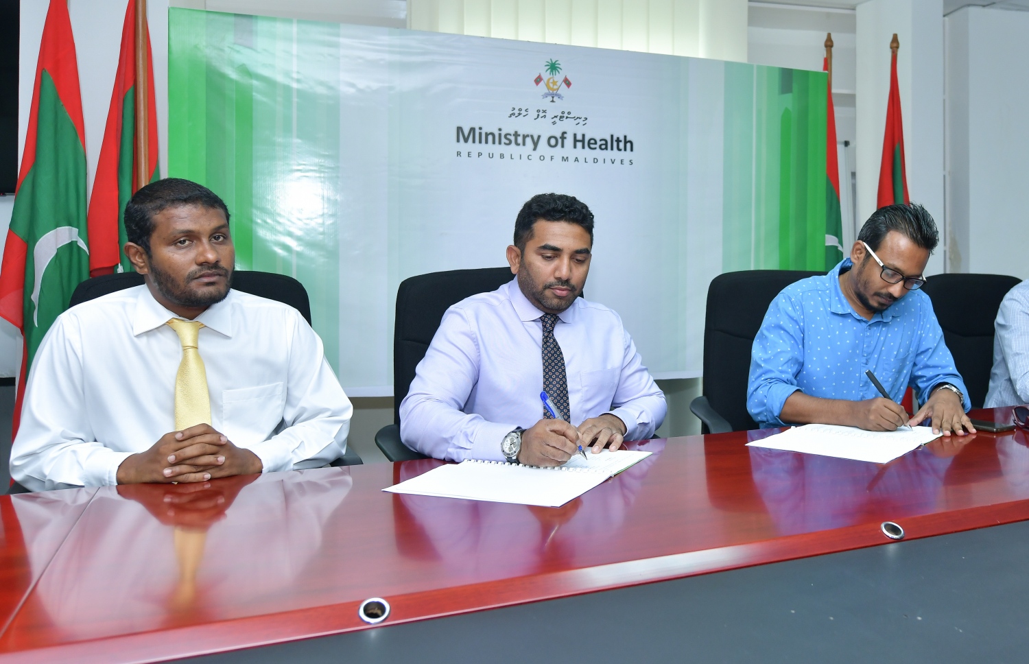 އިހަވަންދޫ ސިއްހީ މަރުކަޒު، ހޮސްޕިޓަލަކަށް ބަދަލުކުރުމުގެ ޑިޒައިން އެއްބަސްވުމުގައި މިނިސްޓަރު އަމީން ސޮއިކުރައްވާއިރު، އެ ދާއިރާގެ މެމްބަރު ޝިފާއު އަރިހުގައި.---ފޮޓޯ: ނިޝާން އަލީ/މިހާރު