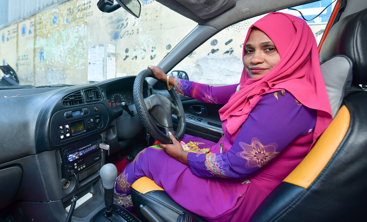 އައިމިނަތު ވަހީދާ އޭނާގެ ޓެކްސީގައި ފޮޓޯއަކަށް ހުއްޓިގެން. -- ފޮޓޯ: ނިޝާން އަލީ