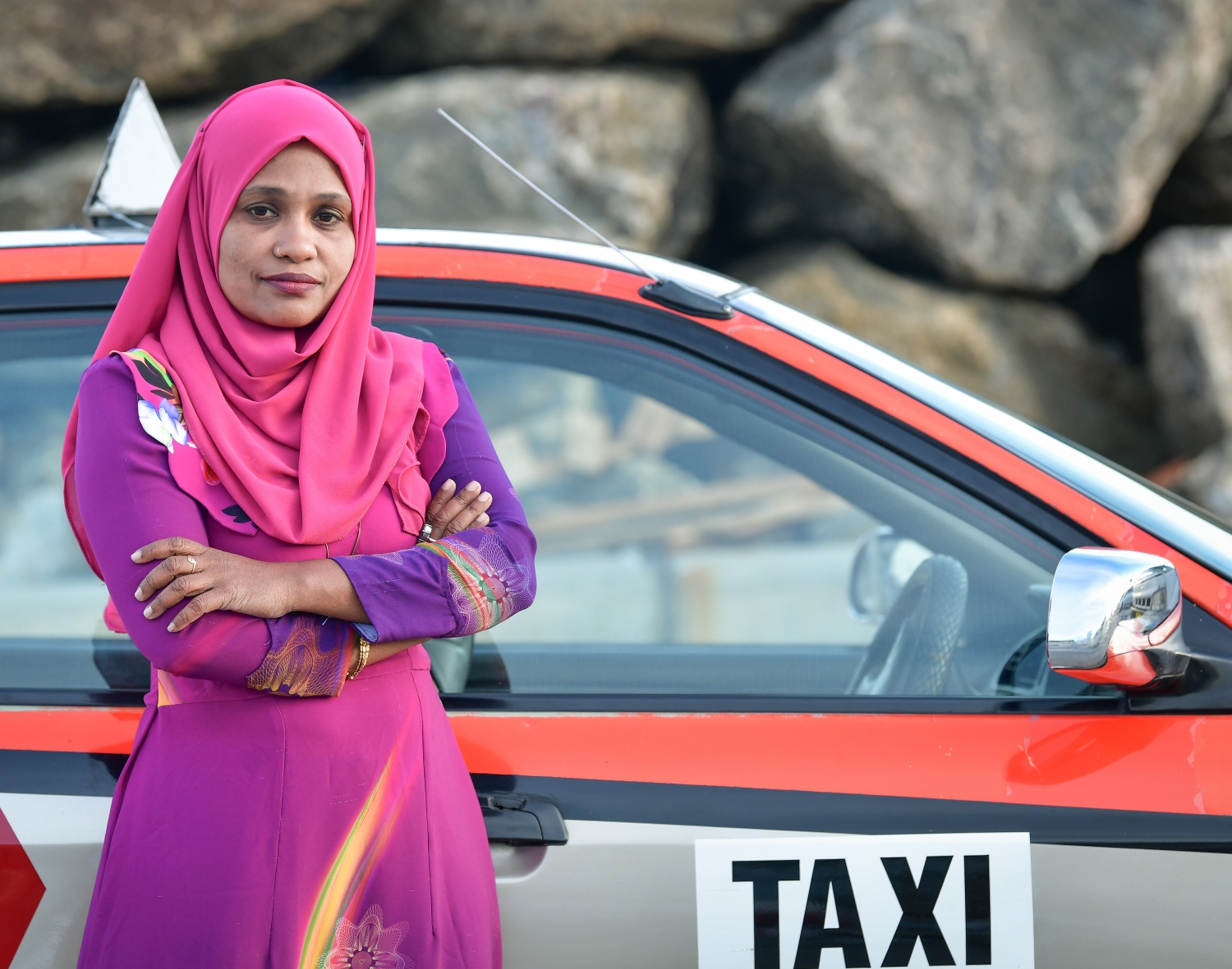 އައިމިނަތު ވަހީދާ އޭނާގެ ޓެކްސީ ކައިރީ ފޮޓޯއަކަށް ހުއްޓިގެން. -- ފޮޓޯ: ނިޝާން އަލީ