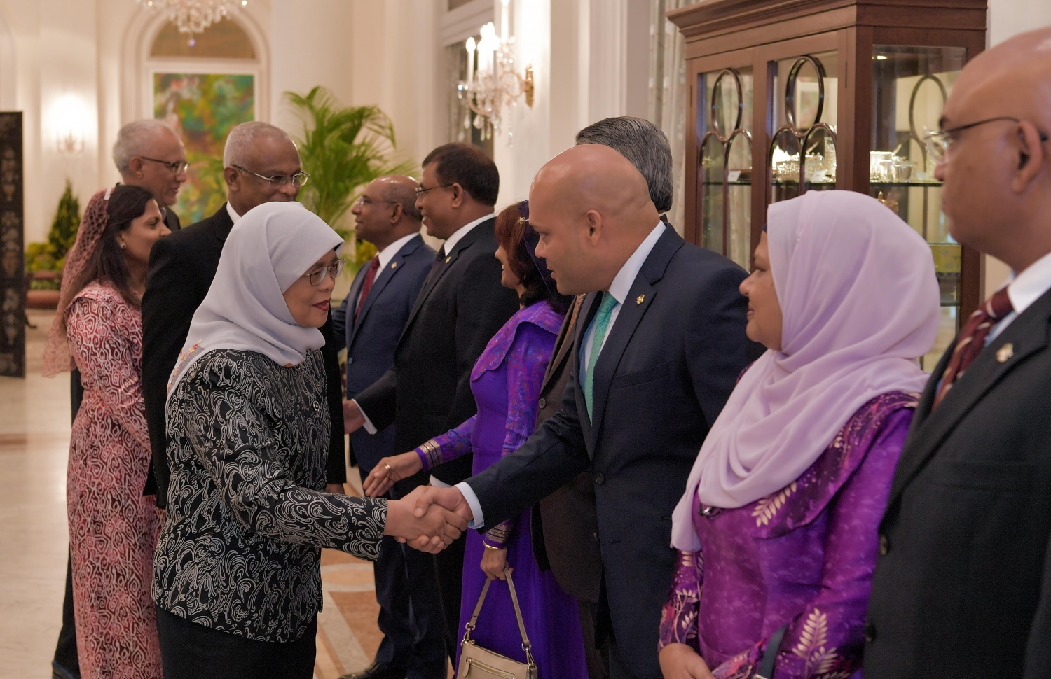 ސިންގަޕޫރު: ޖުލައި 1، 2019: ސިންގަޕޫރުގެ ރައީސްގެ ދައުވަތަކަށް ރައީސްގެ ދެކަނބަލުން މިިހާރު ކުރަމުން ގެންދަވާ ދަތުރުފުޅުގައި އެ ގައުމު ރައީސް ރާއްޖޭގެ ބައެއް އިސްވެރިންނާ ސަލާމް ކުރައްވަނީ.-- ފޮޓޯ: ރައީސް އޮފީސް