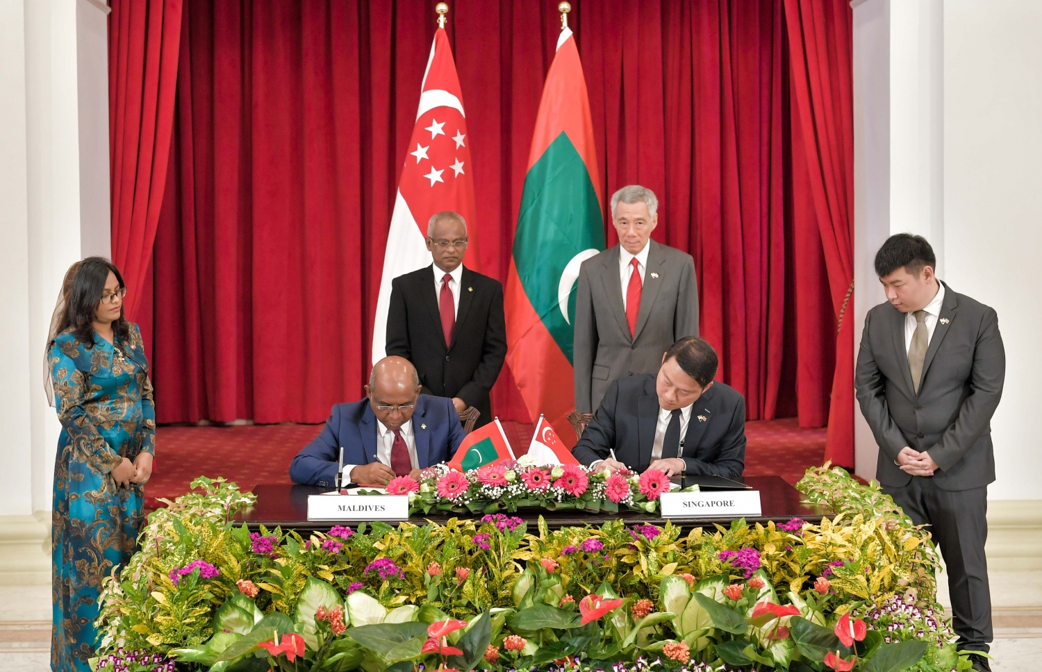 ސިންގަޕޫރު: ޖުލައި 1، 2019: ސިންގަޕޫރުގެ ރައީސްގެ ދައުވަތަކަށް ރައީސްގެ ދެކަނބަލުން މިިހާރު ކުރަމުން ގެންދަވާ ދަތުރުފުޅުގެ ތެރެއިން ރާއްޖެ އާއި ސިންގަޕޫރާ ދެމެދު ވައިގެ ދަތުރުފަަތުރުގެ ދާއިރާގެ އެމްއޯޔޫ އަކާއި ދެ ގައުމުގެ ފޮރިން މިނިސްޓްރީއާ ދެމެދު އެއްބާރުލުން ދިނުމާ ބެހޭ އެމްއޯޔޫއެއްގައި ސޮއި ކުރައްވަނީ.-- ފޮޓޯ: ރައީސް އޮފީސް