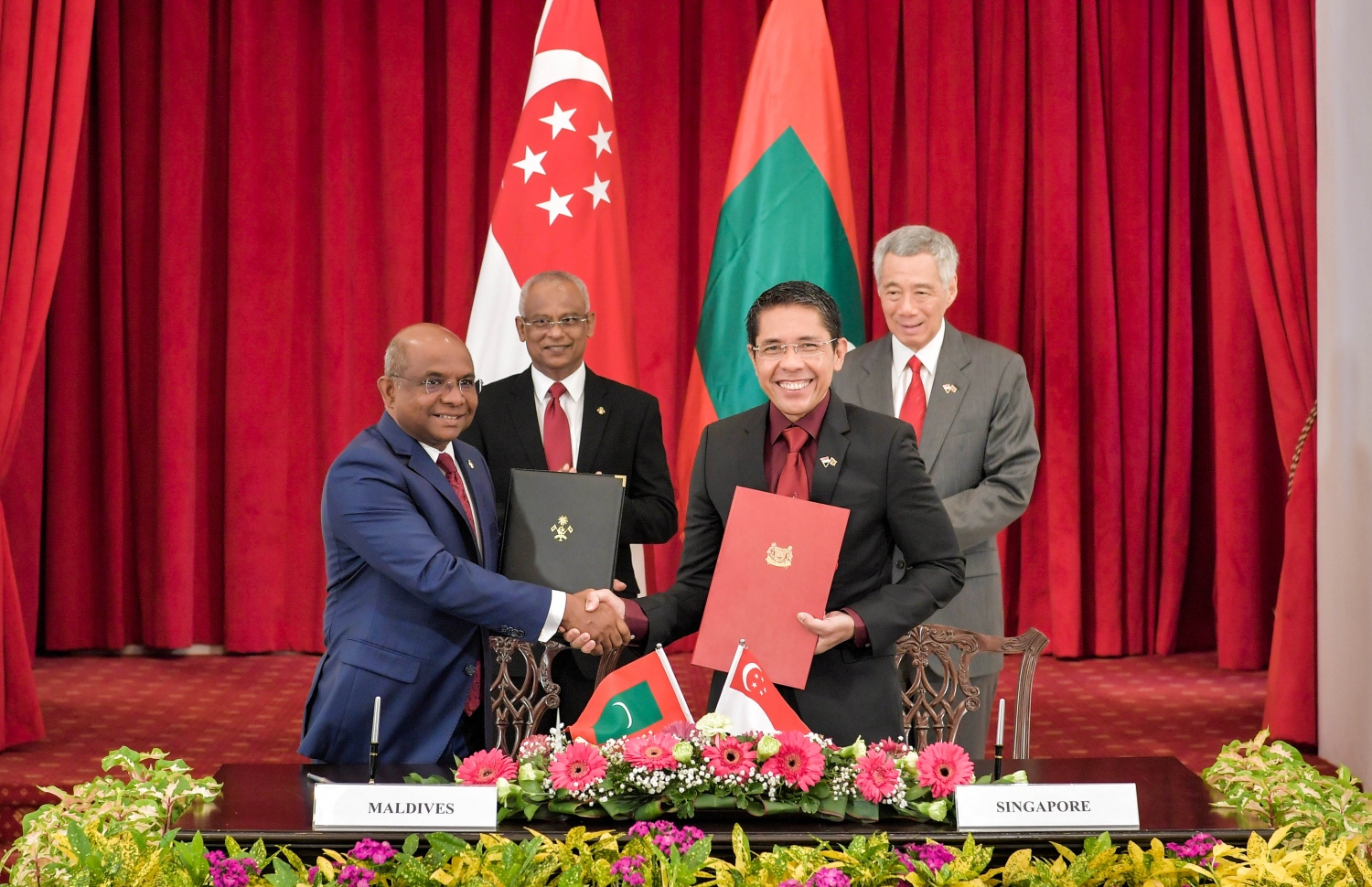 ސިންގަޕޫރު: ޖުލައި 1، 2019: ސިންގަޕޫރުގެ ރައީސްގެ ދައުވަތަކަށް ރައީސްގެ ދެކަނބަލުން މިިހާރު ކުރަމުން ގެންދަވާ ދަތުރުފުޅުގެ ތެރެއިން ރާއްޖެ އާއި ސިންގަޕޫރާ ދެމެދު ވައިގެ ދަތުރުފަަތުރުގެ ދާއިރާގެ އެމްއޯޔޫ އަކާއި ދެ ގައުމުގެ ފޮރިން މިނިސްޓްރީއާ ދެމެދު އެއްބާރުލުން ދިނުމާ ބެހޭ އެމްއޯޔޫއެއްގައި ސޮއި ކުރުމަށްފަހު ލިޔުން ބަދަލުކުރައްވަނީ.-- ފޮޓޯ: ރައީސް އޮފީސް