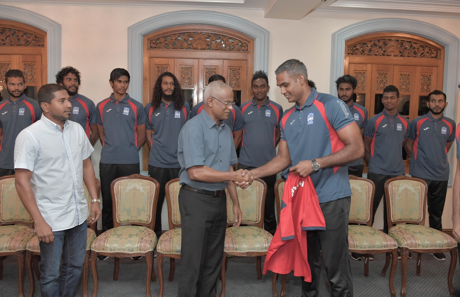 މާލެ: ޖުލައި 3، 2019: ކުރިޔަށް އޮތް އިންޑިއަން އޯޝަންސް އައިލެންޑް ގޭމްސް (އައި.އޯ.އައި.ޖީ) އަށް ތައްޔާރުވުމުގެ ގޮތުން، އިތުރު ތަމްރީނު ހޯދުމަށް ސާބިއާއަށް ދަތުރުކުރުމަށް ހަމަޖެހިފައިވާ ގައުމީ ވޮލީ ޓީމުގެ މެންބަރުންނާ ރައީސް އިބްރާހިމް މުހައްމަދު ސޯލިހު ބައްދަލު ކުރެއްވުމަށް މުލީއާގޭގައި ބޭއްވި ހަފުލާގައި ރައީސް އަށް ޖާޒީއެއް ހަދިޔާ ކުރަނީ.-- ފޮޓޯ: ރައީސް އޮފީސް