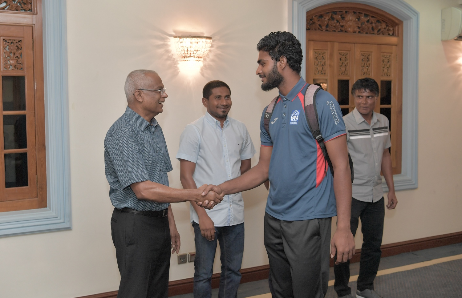 މާލެ: ޖުލައި 3، 2019: ކުރިޔަށް އޮތް އިންޑިއަން އޯޝަންސް އައިލެންޑް ގޭމްސް (އައި.އޯ.އައި.ޖީ) އަށް ތައްޔާރުވުމުގެ ގޮތުން، އިތުރު ތަމްރީނު ހޯދުމަށް ސާބިއާއަށް ދަތުރުކުރުމަށް ހަމަޖެހިފައިވާ ގައުމީ ވޮލީ ޓީމުގެ މެންބަރުންނާ ރައީސް އިބްރާހިމް މުހައްމަދު ސޯލިހު ބައްދަލު ކުރެއްވުމަށް މުލީއާގޭގައި ބޭއްވި ހަފުލާގައި ކުޅުންތެރިއަކާއި ރައީސް ސަލާމް ކުރައްވަނީ.-- ފޮޓޯ: ރައީސް އޮފީސް