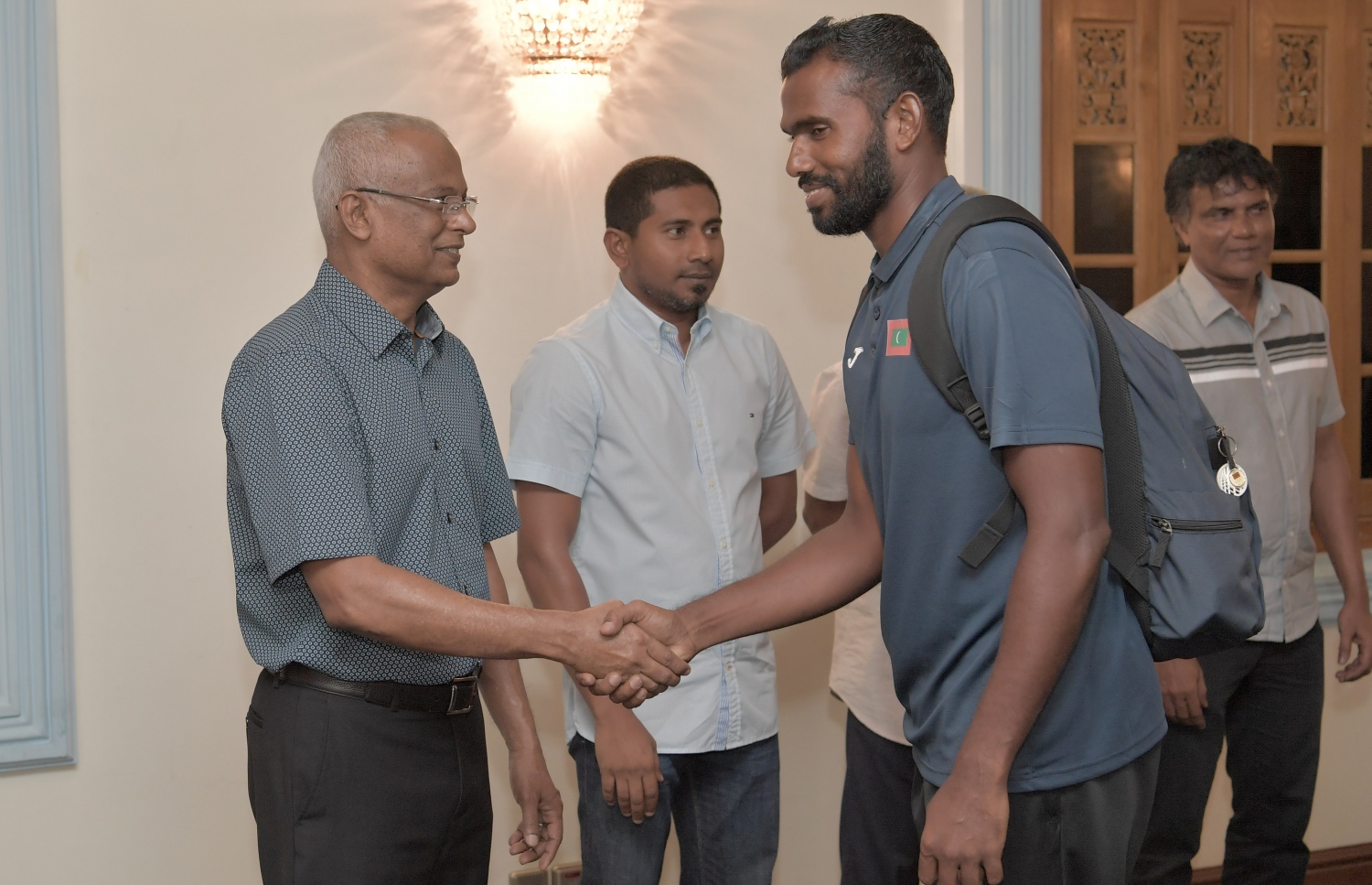 މާލެ: ޖުލައި 3، 2019: ކުރިޔަށް އޮތް އިންޑިއަން އޯޝަންސް އައިލެންޑް ގޭމްސް (އައި.އޯ.އައި.ޖީ) އަށް ތައްޔާރުވުމުގެ ގޮތުން، އިތުރު ތަމްރީނު ހޯދުމަށް ސާބިއާއަށް ދަތުރުކުރުމަށް ހަމަޖެހިފައިވާ ގައުމީ ވޮލީ ޓީމުގެ މެންބަރުންނާ ރައީސް އިބްރާހިމް މުހައްމަދު ސޯލިހު ބައްދަލު ކުރެއްވުމަށް މުލީއާގޭގައި ބޭއްވި ހަފުލާގައި ކުޅުންތެރިއަކާއި ރައީސް ސަލާމް ކުރައްވަނީ.-- ފޮޓޯ: ރައީސް އޮފީސް