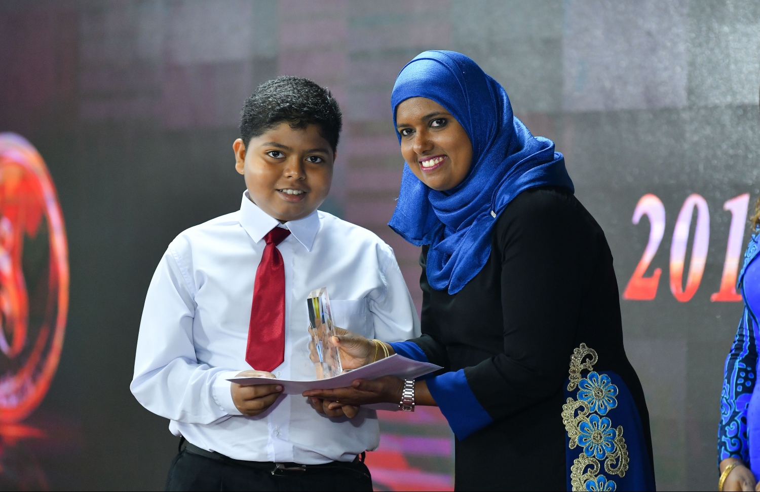 މާލެ: ޖުލައި 8، 2019- ނުކުޅެދުންތެރިކަން ހުންނަ މީހުންނާއި އެ ދާއިރާގައި މަސައްކަތް ކުރާ ފަރާތްތަކުގެ އަގު ވަޒަންކުރުމުގެ ގޮތުން ސަރުކާރުން ދޭ ރިވެލި އެވޯޑް ދިނުމުގެ ހަފްލާގައި ޖެންޑާ މިނިސްޓަރު ޝިދާތާ، ރިވެލި އެވޯޑު ހާސިލުކުރި ފަރާތަކަށް އެވޯޑު ދެއްވަނީ.---ފޮޓޯ: ހުސައިން ވަހީދު/މިހާރު