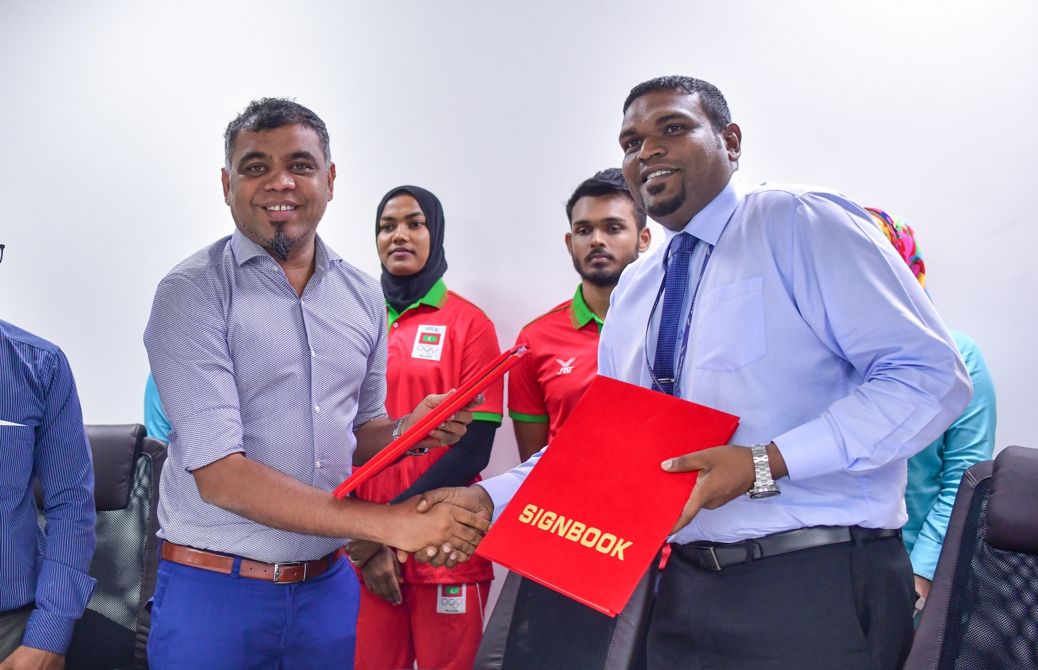 އައިލެންޑް އޭވިއޭޝަނުގެ މެނޭޖިން ޑިރެކްޓަރު ރިޒްވީ (ކ) އާއި އޮލިމްޕިކް ކޮމިޓީގެ ސެކްރެޓަރީ ޖެނެރަލް މަރުޒޫގު އެއްބަސްވުން ބަދަލުކުރަނީ. --ފޮޓޯ: ނިޝާން އަލީ/ މިހާރު