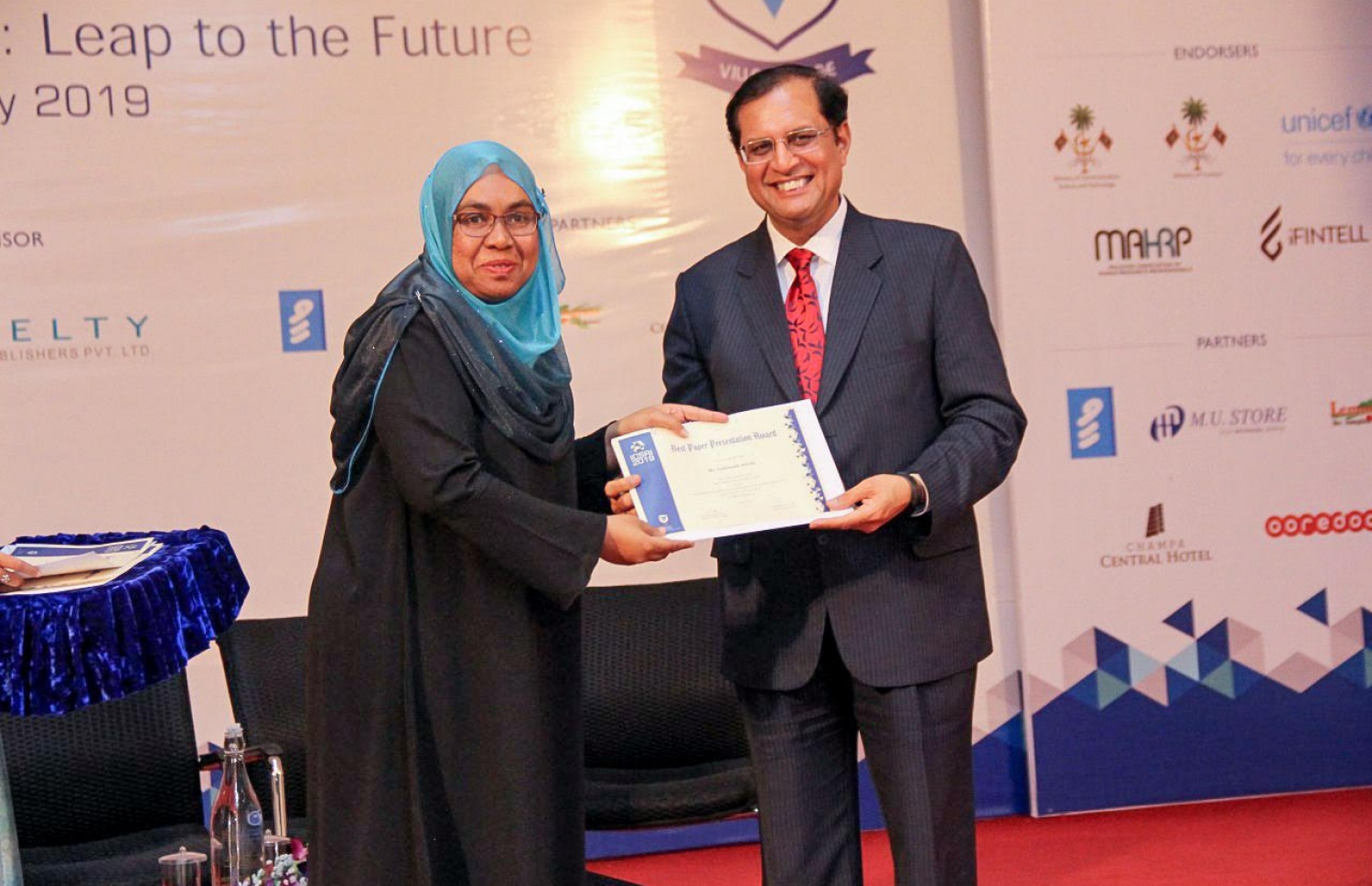 ވިލާ ކޮލެޖުގެ ރިސާޗު ކޮންފަރެންސްގައި ބައިވެރިވި މީހަކަށް، ޑަބްލިއުއެޗްއޯއިން ރާއްޖެ ކަނޑައަޅާފައި ހުންނަވާ މަންދޫބު ޑރ. އަރްވިންދް މާތުރް ސެޓްފިކެޓް ހަވާލުކޮށްދެއްވަނީ.--ފޮޓޯ: ވިލާ ކޮލެޖު