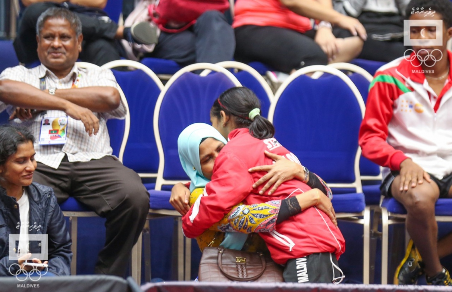 ދީމާ ޑަބަލްސް ރަން މެޑަލް ހޯދުމަށް ފަހު މަންމަ ގައިގައި ބައްދާލާއިރު ބައްޕަ (ވ) ހިނިތުންވެފައި. –-އެމްއޯސީ ފޮޓޯ: އިސްމާއިލް ތޯރިގް