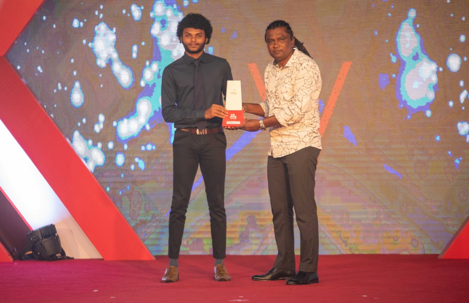 އިންޑިވިޖުއަލް ކެޓަގަރީން 21 އަހަރުން ދަށުގެ އެންމެ މޮޅު ކުޅުންތެރިޔަކަށް ހޮވުނު ނާއިލް (ވ) އަށް ފުޓްބޯޅަ ކޯޗު އަލީ ސުޒޭން އިނާމް ދެނީ. --މިހާރު ފޮޓޯ: އިމޭޖަސް އެމްވީ