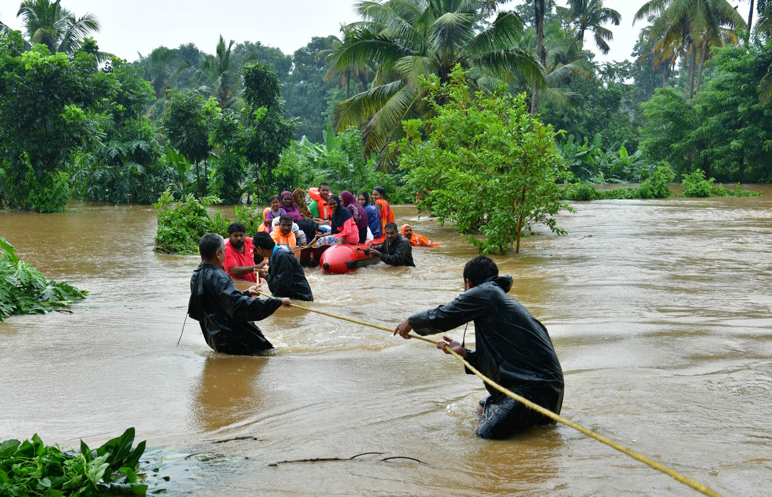 އިންޑިއާގެ ދެކުނުގެ ކެރަލާ ސްޓޭޓުގެ އެރްނާކްލަމް އަވަށުގައި ފެންބޮޑުވެ ހާލުގައި ޖެހުނު ބަޔަކު ސަލާމަތް ކުރަނީ. --ފޮޓޯ:އޭއެފްޕީ