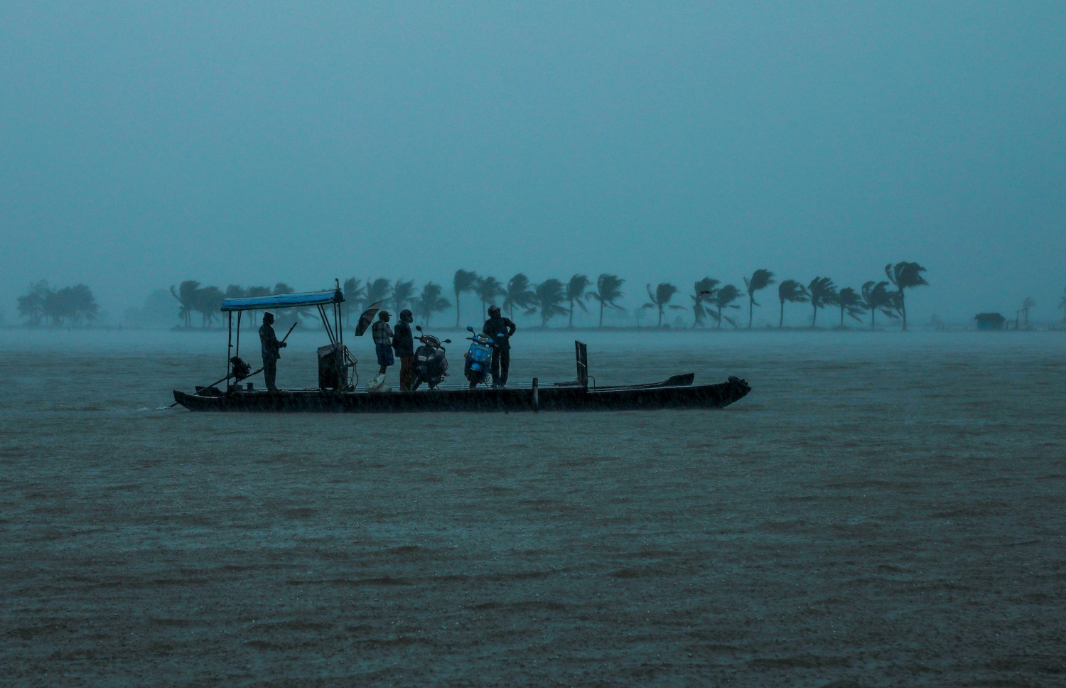 އިންޑިއާގެ ދެކުނުގެ ކެރަލާ ސްޓޭޓުގެ ކޮޗިންގައި ފެންބޮޑުވެ ހާލުގައި ޖެހުނު ބަޔަކު ރައްކާތެރިކަމުގެ ހިސާބަކަށް ގެންދަނީ. --ފޮޓޯ:އޭއެފްޕީ