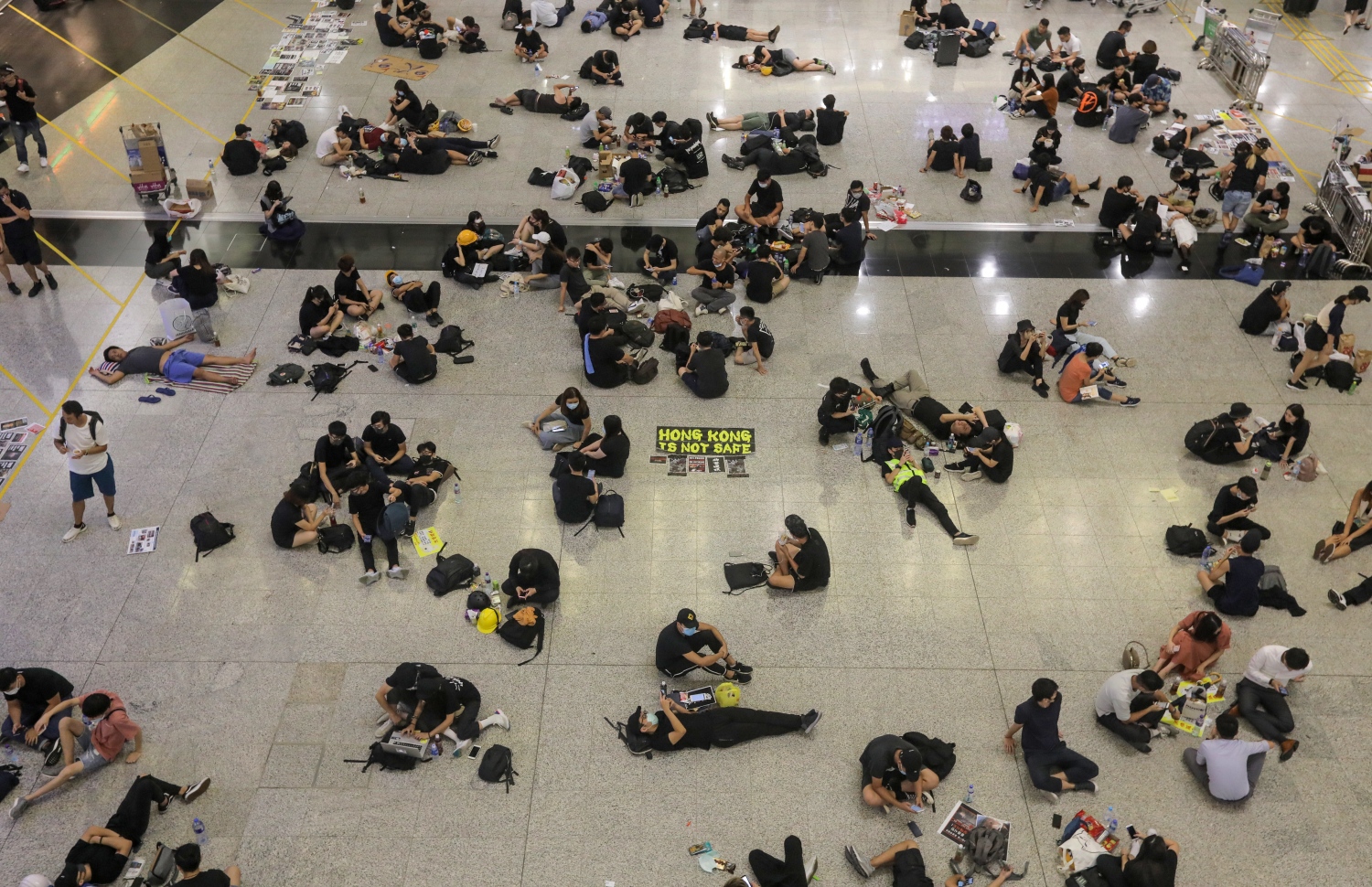 ހޮން ކޮން: އޮގަސްޓް 13، 2019: ހޮން ކޮން އެއާޕޯޓުގައި މުޒާހަރާ ކުރާ މީހުން ބިންމަތީގައި. --ފޮޓޯ:އޭއެފްޕީ