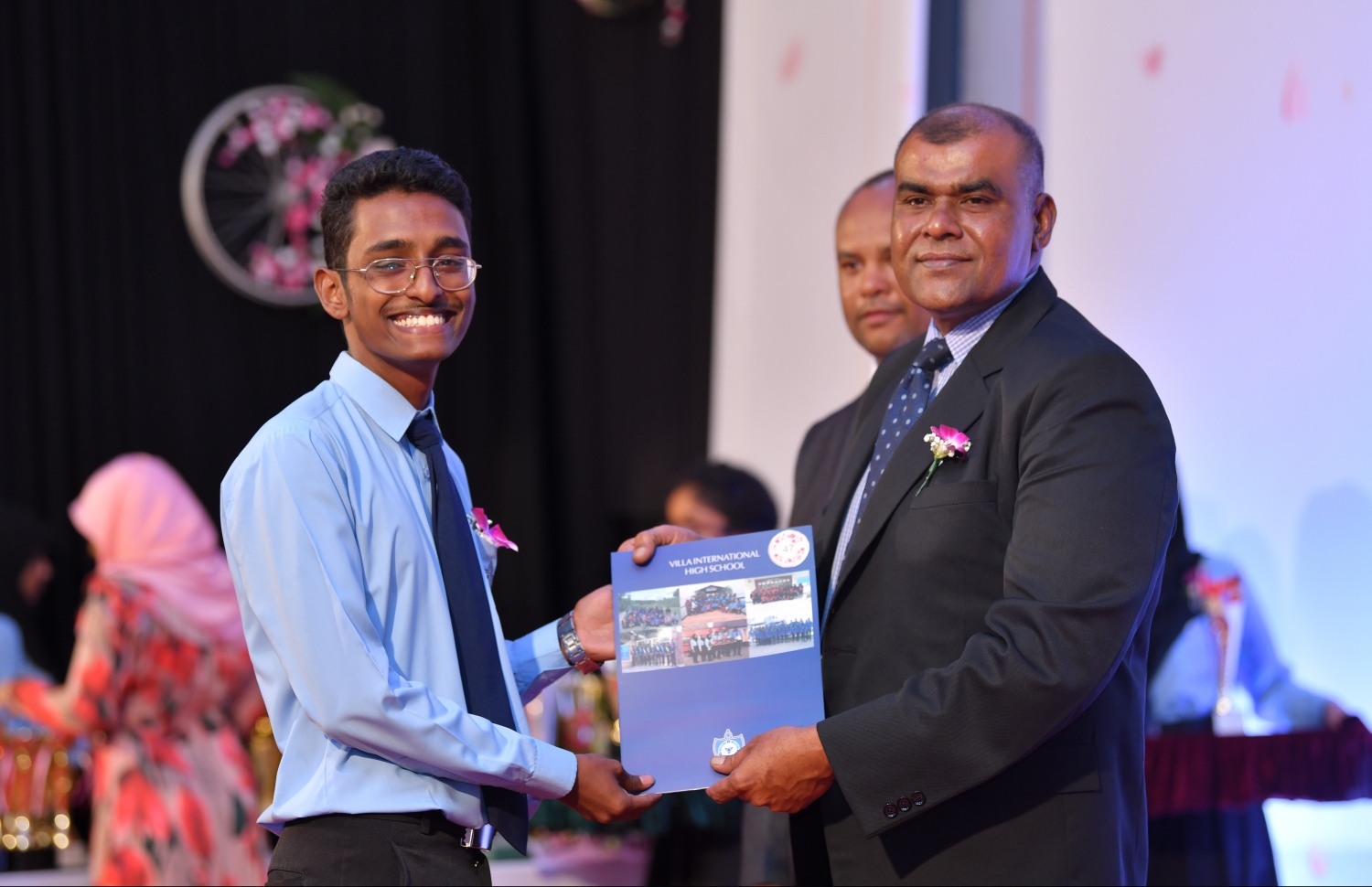 މާލެ: އޮގަސްޓް 28، 2019: ވިލާ އިންޓަނޭޝަނަލް ހައި ސްކޫލުގައި ބޭއްވި އެ ސްކޫލުގެ އިނާމުދިނުމުގެ ޖަލްސާގައި ޖަމާލުއްދީން ސްކޫލުގެ ޕްރިންސިޕަލް ހަސަން، އެ ސްކޫލުގެ ދަރިވަރަކަށް ހަނދާނީ ލިޔުމެއް ދެއްވަނީ.-- ފޮޓޯ: ހުސެން ވަހީދު /މިހާރު