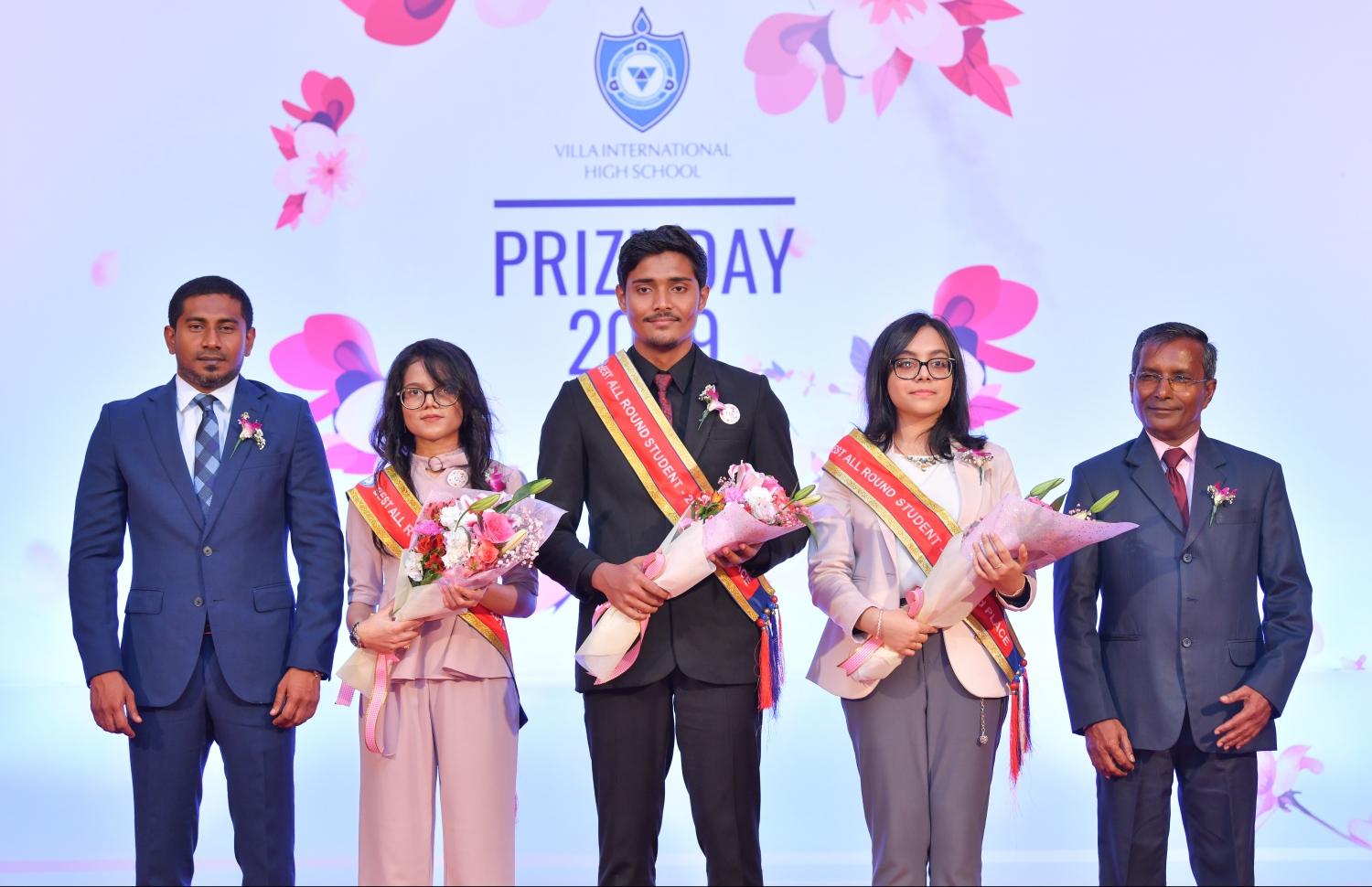 ވިލާ އިންޓަނޭޝަނަލް ހައި ސްކޫލުން މިދިޔަ އަހަރު ހުރިހާ ގޮތަކުން އެންމެ މޮޅު ދަރިވަރަކަށް ހޮވުނު އަހުނަފު (މ) ދެ ވަނަ ލިބުނު ޒަކާ (ކ-2) އަދި ތިން ވަނަ ލިބުނު ސަޖާޔާ (ވ-2)، ޔޫތު މިނިސްޓަރު މަހުލޫފު (ވ) އަދި އެ ސްކޫލުގެ ޕްރިންސިޕަލް ސައީދާއެކު ފޮޓޯއަކަށް ހުއްޓިލައިގެން.- ފޮޓޯ: ހުސެއިން ވަހީދު/ މިހާރު