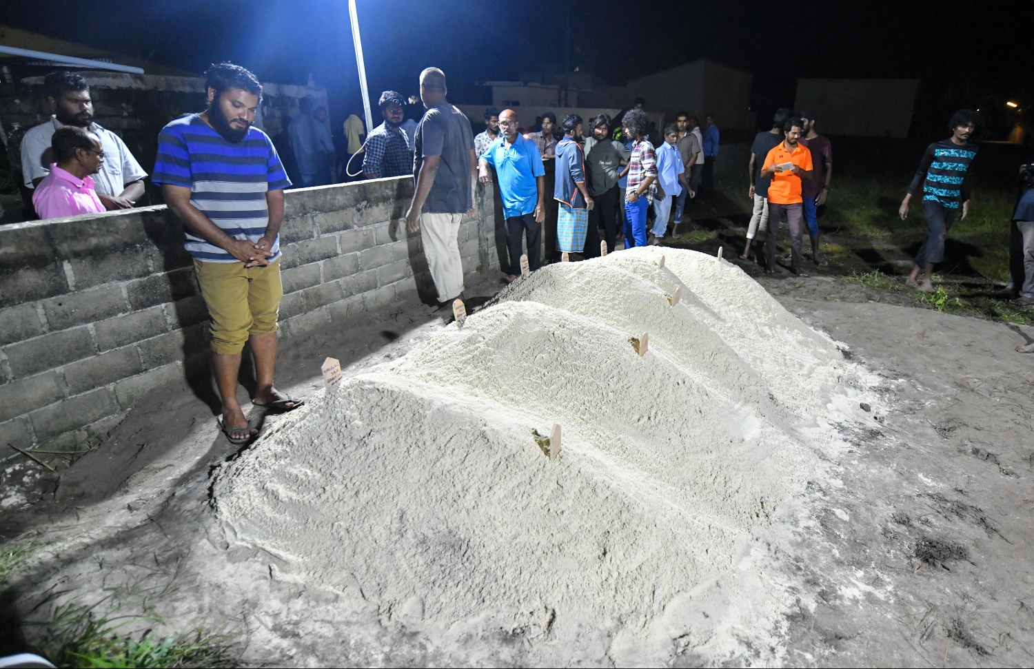 ލޯންޗު ބަންޑުން ޖަހާލި ހާދިސާގައި މަރުވި މީހުންގެ ޖަނާޒާ ނިމުމުން މަހާނަތައް ކައިރީގައި އަބްދުﷲ ވަހީދު އިސްދަށަށް ޖަހައިގެން -- ފޮޓޯ: ހުސައިން ވަހީދު /މިހާރު