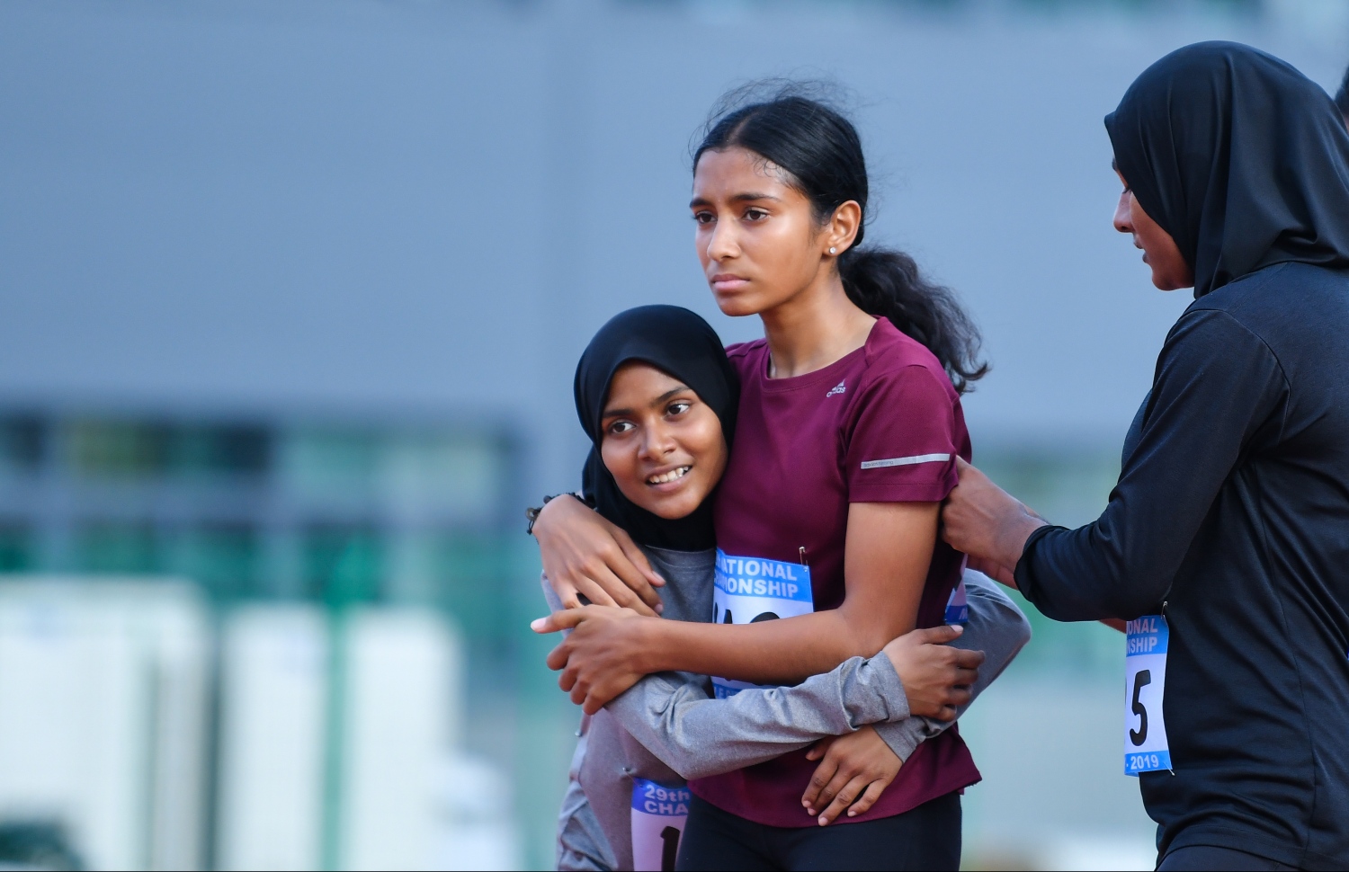 ހިމްނާ (މ) 100 މީޓަރު ދުވުން ކާމިޔާބުކުރުމުން، އޭނާގެ ދެ ވާދަވެރިން ކަމަށްވާ އަލްހާ (ވ) އާއި ނަޝާ މަރުހަބާ ކިޔަނީ. –ފޮޓޯ: ހުސެއިން ވަހީދު/ މިހާރު