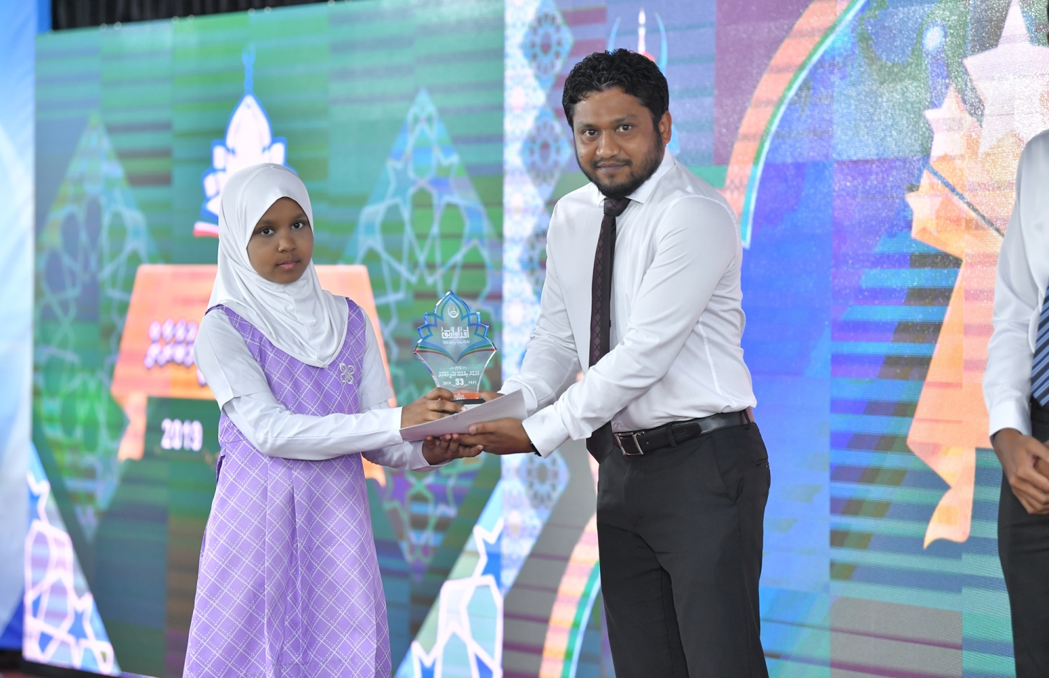 މާލެ: ސެޕްޓެމްބަރު 7، 2019: 33 ވަނަ ގައުމީ ގުރުއާން މުބާރާތުގެ ނަތީޖާ ފާޅުކުރުމަށް އިސްލާމީ މަރުކަޒުގައި ބޭއްވި ރަސްމިއްޔާތުގައި ރައީސް އޮފީހުގެ ޗީފް އޮފް ސްޓާފް އަލީ ޒާހިރު ދަރިވަރަކަށް އިނާމު ހަވާލު ކުރައްވަނީ.-- ފޮޓޯ: ރައީސް އޮފީސް