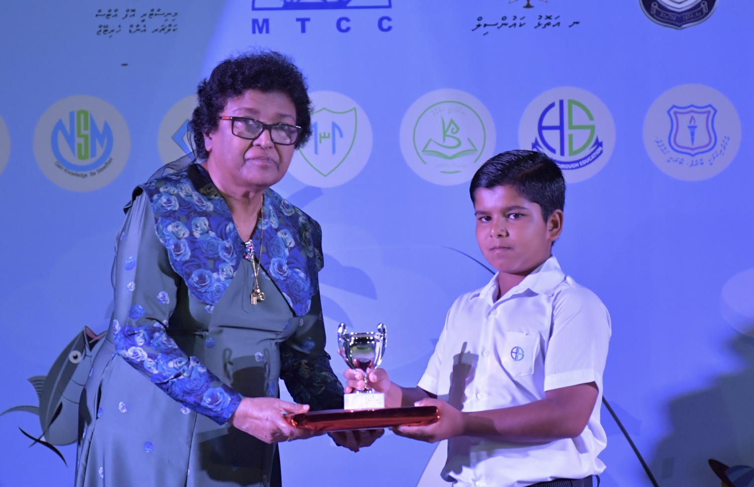 ނ. މަނަދޫ: ސެޕްޓެމްބަރު 14، 2019: މަނަދޫ ބަނދަރު ސަރަޙައްދުގައި ބޭއްވި 'މިލަދެކުނު އަދަބީ އީދު 2019'  ނިންމުމުގެ ޖަލްސާގައި އެ ސްކޫލުގެ ދަރިވަރަކަށް އިނާމު ހަވާލުކޮށްދެއްވަނީ.-- ފޮޓޯ: ރައީސް އޮފީސް